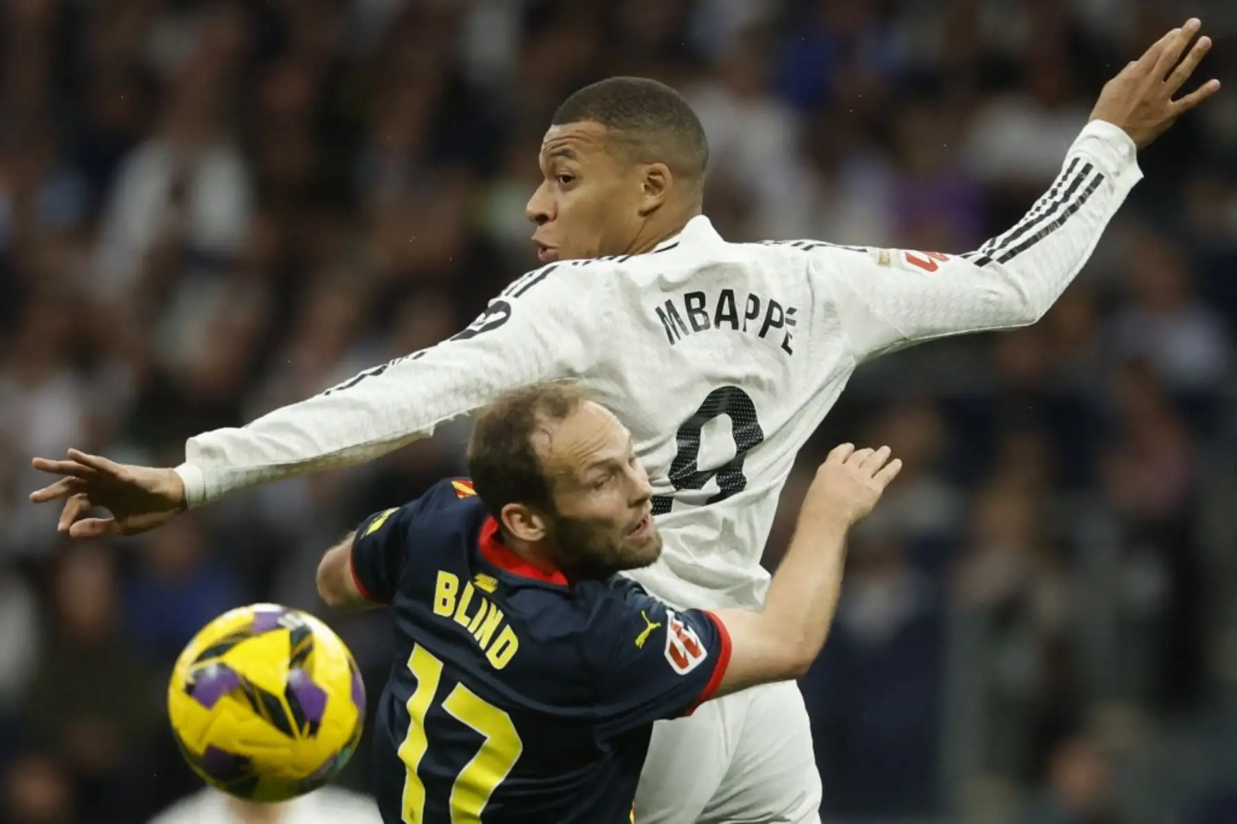 El defensa holandés del Girona #17 Daley Blind y el delantero francés del Real Madrid #09 Kylian Mbappe compiten por el balón durante el partido de fútbol de la liga española entre el Real Madrid CF y el Girona FC en el estadio Santiago Bernabéu de Madrid el 23 de febrero de 2025. (Foto de Pierre-Philippe MARCOU / AFP)
