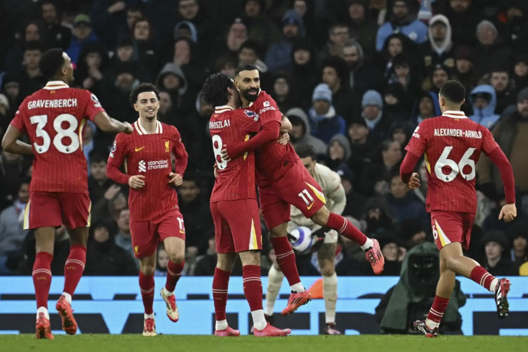 El centrocampista húngaro del Liverpool #08 Dominik Szoboszlai celebra el segundo gol del equipo con el delantero egipcio #11 del Liverpool, Mohamed Salah, durante el partido de fútbol de la Premier League inglesa entre el Manchester City y el Liverpool en el Etihad Stadium de Manchester, al noroeste de Inglaterra, el 23 de febrero de 2025. (Foto de Paul ELLIS / AFP)