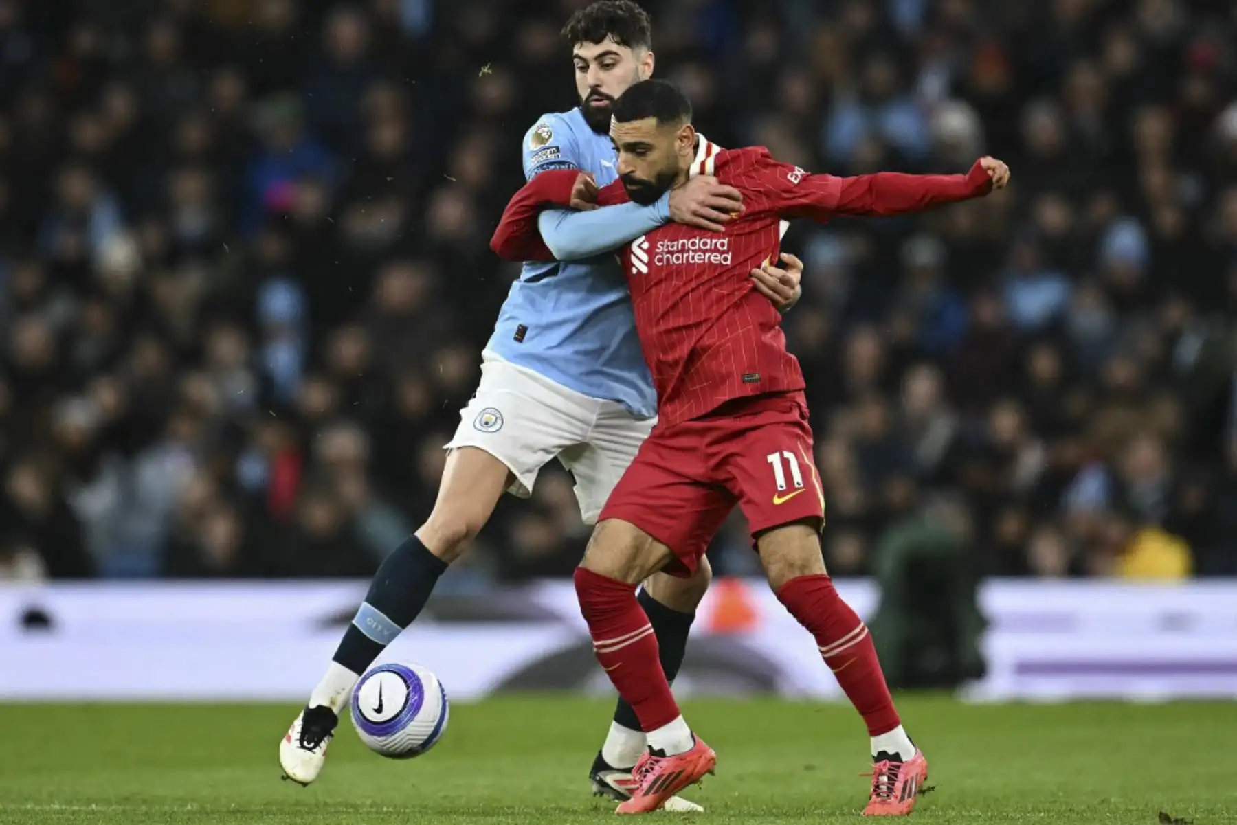 El defensor croata del Manchester City #24 Josko Gvardiol (L) se pelea con el delantero egipcio del Liverpool #11 Mohamed Salah durante el partido de fútbol de la Premier League inglesa entre el Manchester City y el Liverpool en el Etihad Stadium de Manchester, noroeste de Inglaterra, el 23 de febrero de 2025. (Foto de Paul ELLIS / AFP)