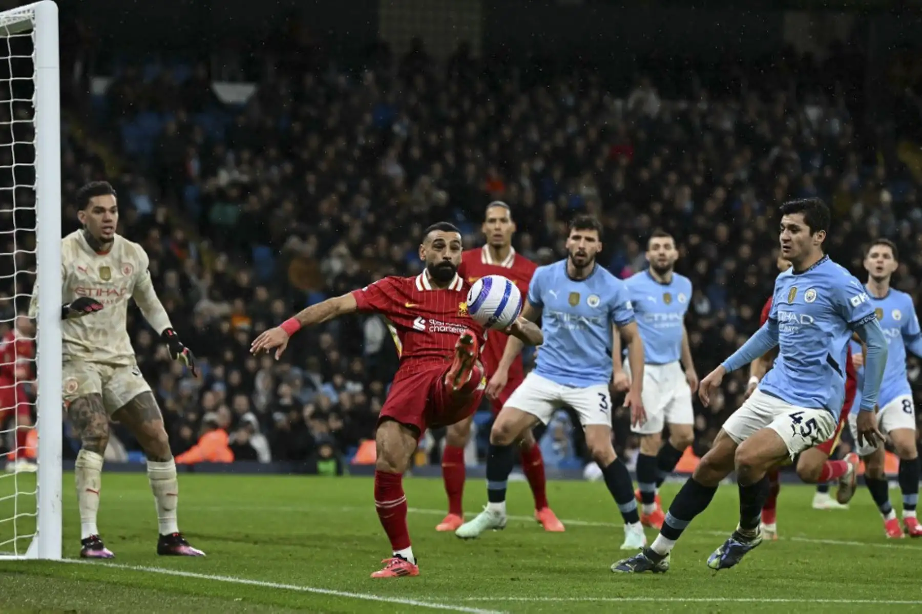 El delantero egipcio #11 del Liverpool, Mohamed Salah, defiende el balón del defensor uzbeko del Manchester City #45 Abdukodir Khusanov durante el partido de fútbol de la Premier League inglesa entre el Manchester City y el Liverpool en el Estadio Etihad de Manchester, noroeste de Inglaterra, el 23 de febrero de 2025. (Foto de Paul ELLIS / AFP)