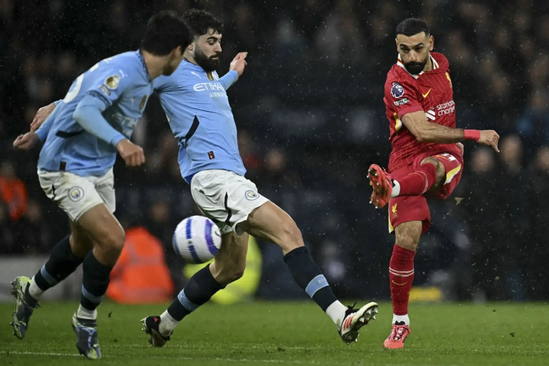 El delantero egipcio #11 del Liverpool, Mohamed Salah (R), dispara más allá del defensor croata del Manchester City #24 Josko Gvardiol, pero tiene su tiro salvado durante el partido de fútbol de la Premier League inglesa entre el Manchester City y el Liverpool en el Estadio Etihad de Manchester, al noroeste de Inglaterra, el 23 de febrero de 2025. (Foto de Paul ELLIS / AFP)