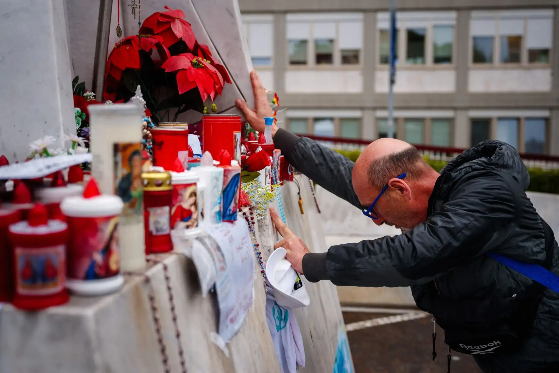 Un hombre reza ante la estatua de Juan Pablo II en el Hospital Universitario Gemelli, donde el Papa Francisco está hospitalizado con neumonía, en Roma.
Foto: AFP