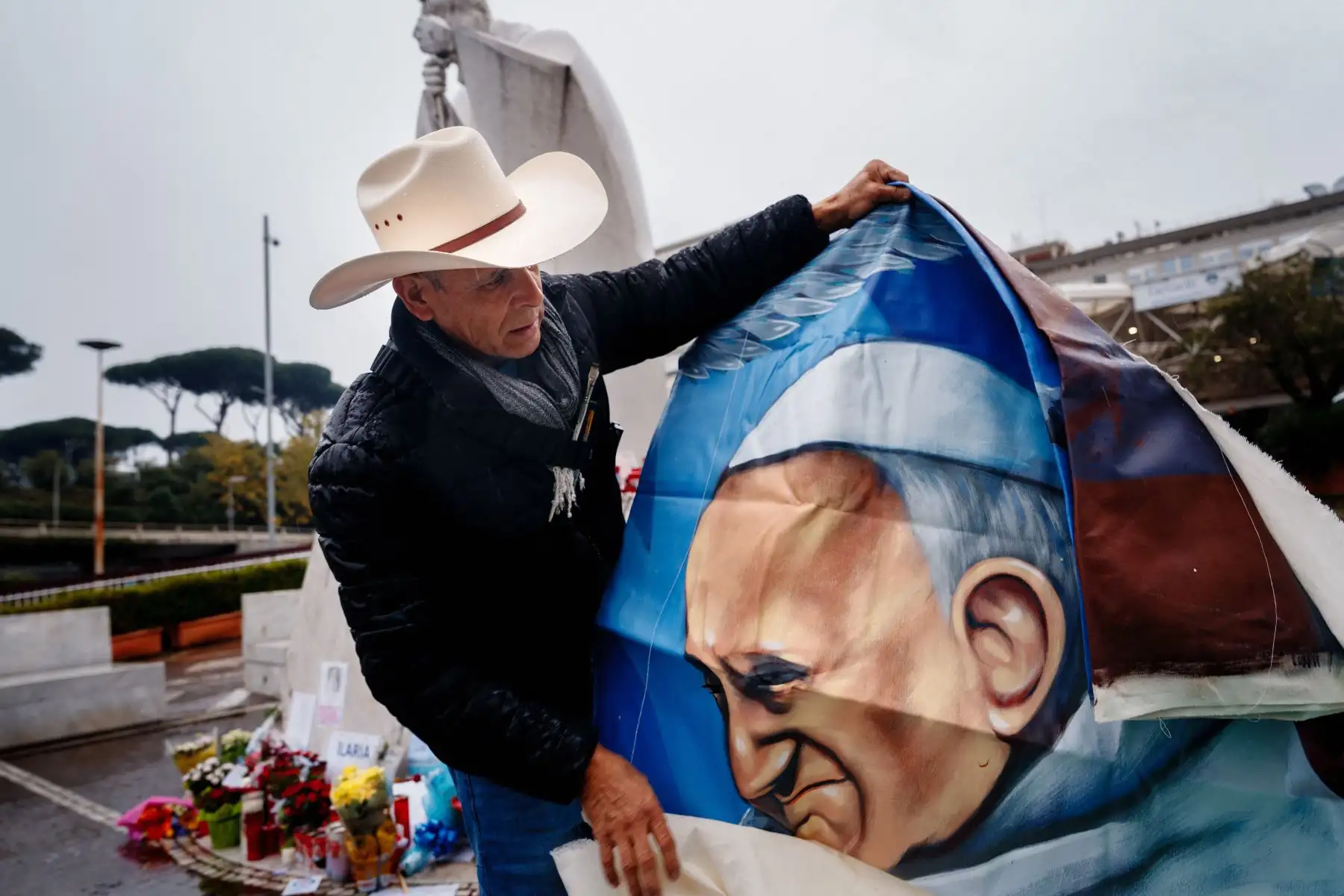 El artista mexicano Roberto Márquez, de Guadalajara, muestra su pintura del Papa Francisco cerca de la estatua de Juan Pablo II en el Hospital Universitario Gemelli donde el Papa Francisco está hospitalizado con neumonía, en Roma.
Foto: AFP