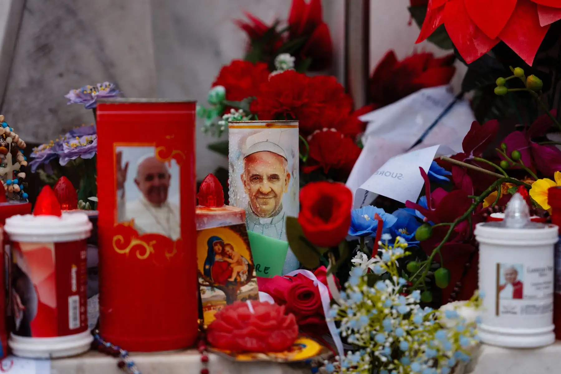 Se colocan velas y flores ante la estatua de Juan Pablo II en el Hospital Universitario Gemelli, donde el Papa Francisco está hospitalizado con neumonía, en Roma.
Foto: AFP