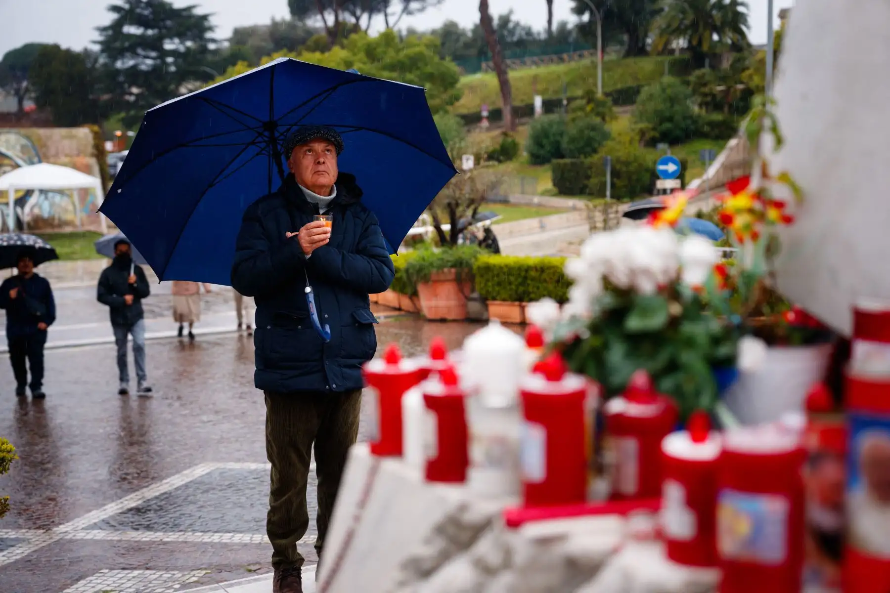 Un hombre reza bajo la lluvia ante la estatua de Juan Pablo II en el Hospital Universitario Gemelli, donde el Papa Francisco está hospitalizado con neumonía, en Roma.
Foto: AFP