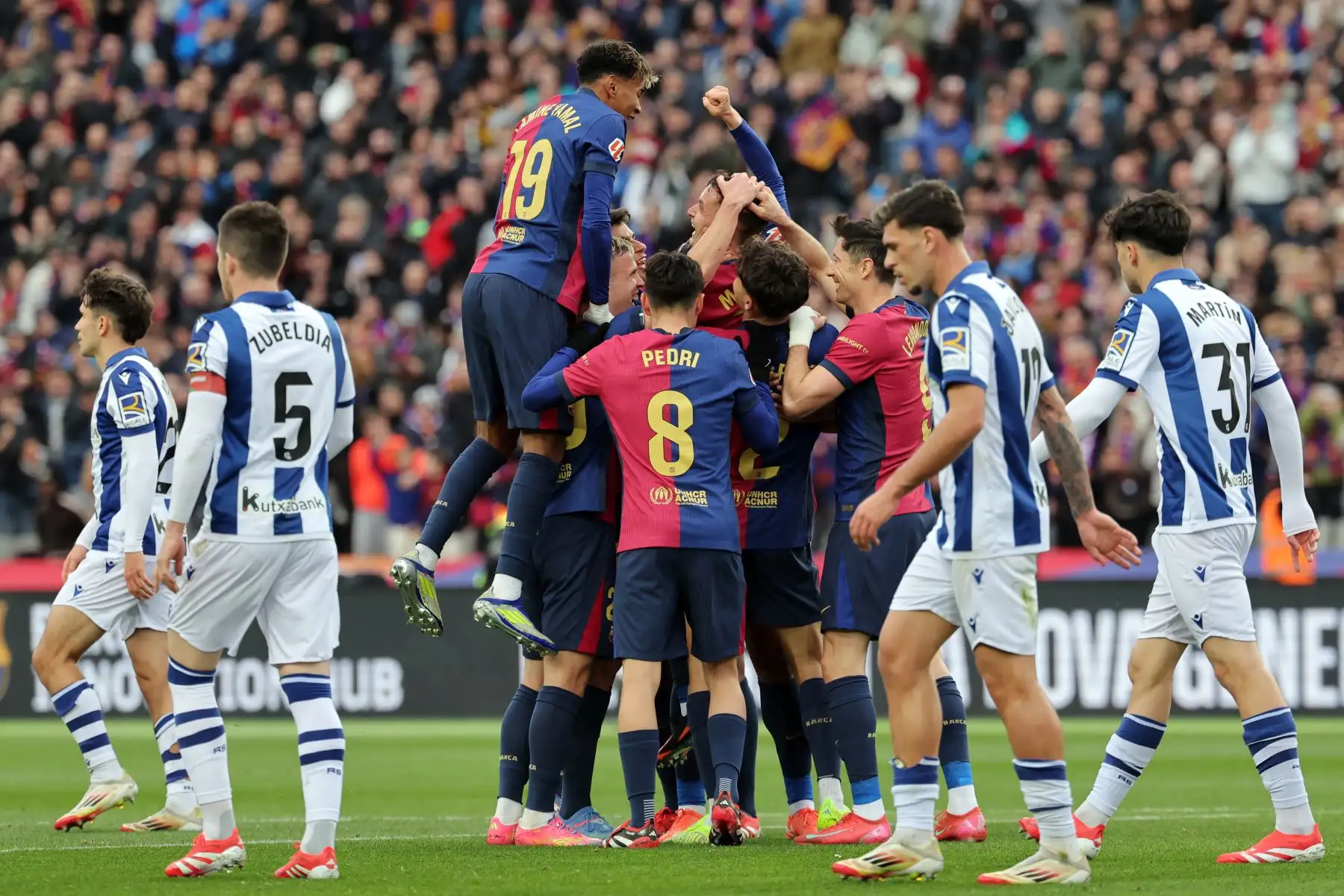 El centrocampista español del Barcelona, ​​Marc Casado, celebra con sus compañeros de equipo después de anotar el segundo gol de su equipo durante el partido de fútbol de la liga española entre el FC Barcelona y la Real Sociedad. Foto: ANDINA/AFP