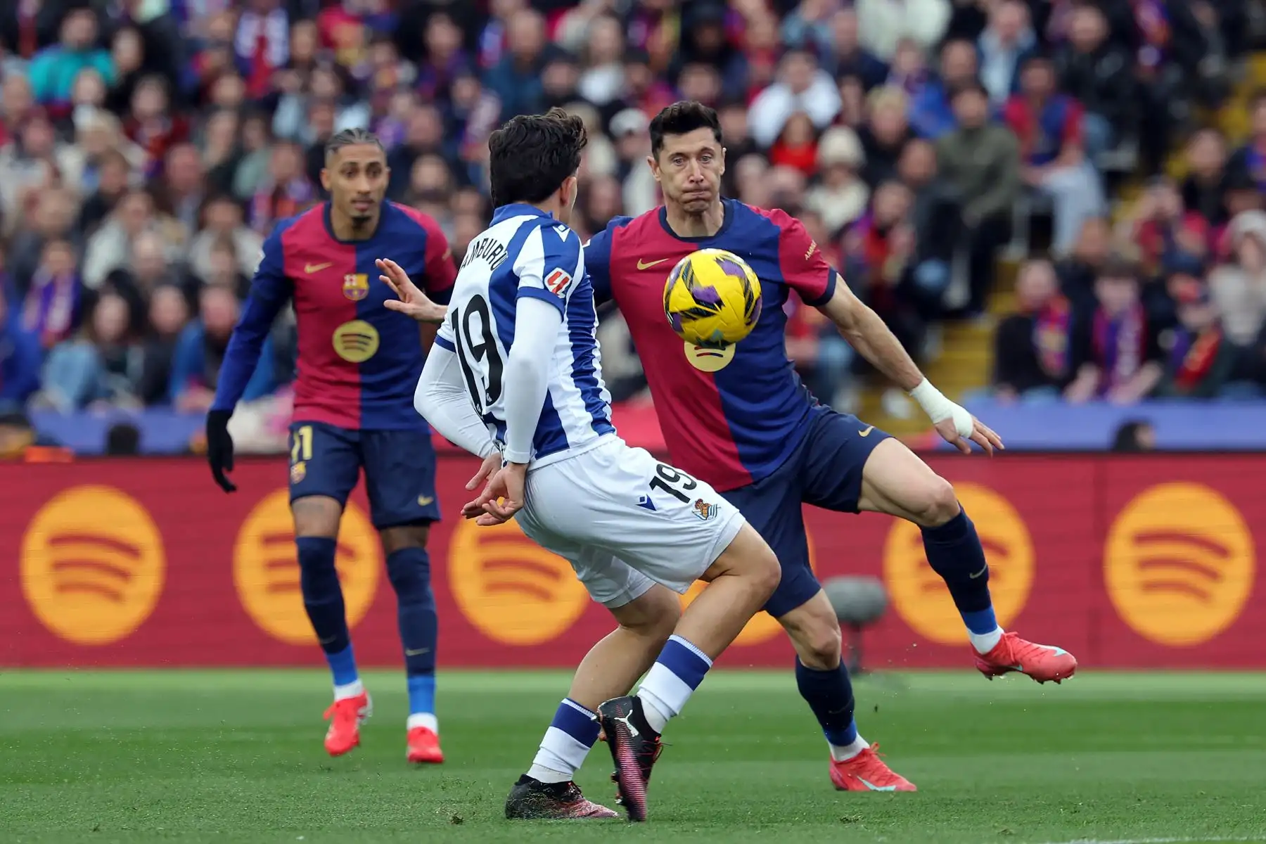 El delantero polaco del Barcelona Robert Lewandowski  y el defensa venezolano de la Real Sociedad  Jon Aramburu compiten por el balón durante el partido de fútbol de la liga española entre el FC Barcelona y la Real Sociedad. Foto: ANDINA/ AFP