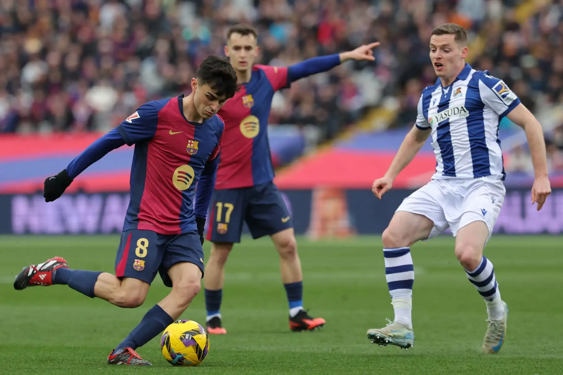 El centrocampista español del Barcelona, ​​Pedri, es desafiado por el defensor español de la Real Sociedad, Sergio Gómez, durante el partido de fútbol de la liga española entre el FC Barcelona y la Real Sociedad. Foto: ANDINA/AFP