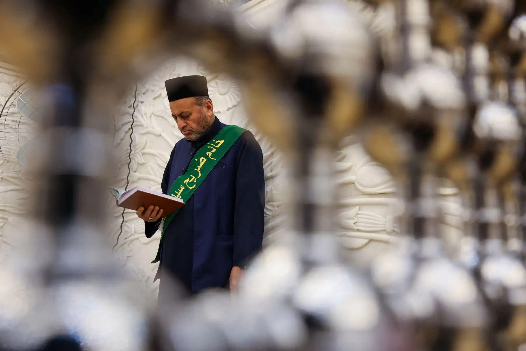 Un hombre lee una copia del Corán en el santuario del jeque sunita Abdul Qadir al-Jilani en Bagdad durante el mes sagrado musulmán del Ramadán. AFP