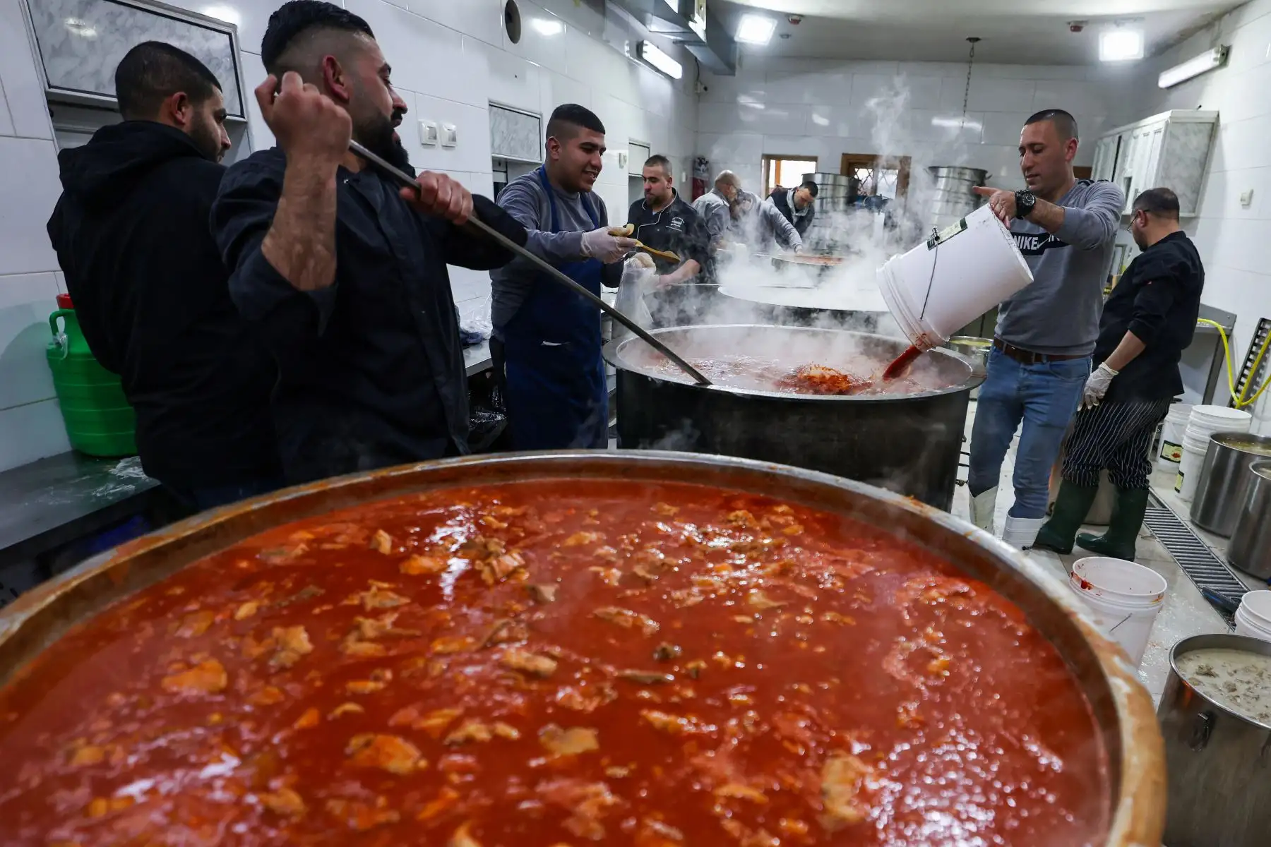 Los empleados del Waqf islámico palestino cocinan alimentos para distribuir durante el mes sagrado musulmán del Ramadán. AFP
