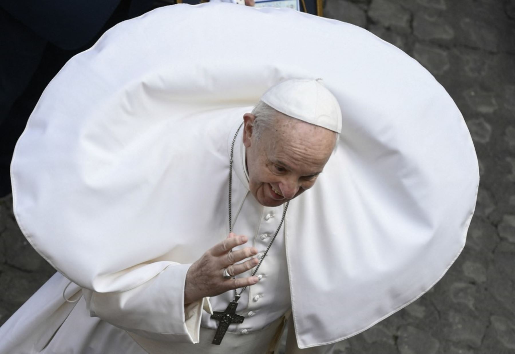 Una ráfaga de viento levanta la sotana del papa Francisco durante su audiencia general semanal al aire libre con público el 19 de mayo de 2021 en el patio de San Dámaso en el Vaticano. Foto: AFP