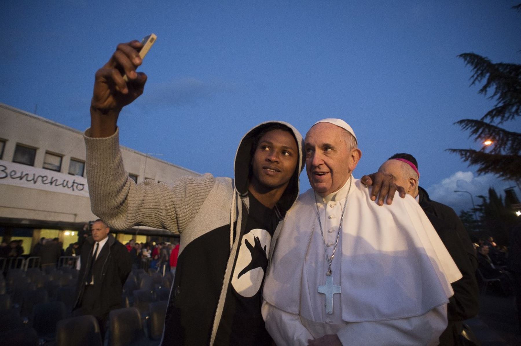 El papa Francisco posa para un selfie con un migrante durante su visita al centro de refugiados de Castelnuovo di Porto, cerca de Roma, el 24 de marzo de 2016. El Papa Francisco lavó los pies de 11 jóvenes solicitantes de asilo y de un trabajador de su centro de recepción para destacar la necesidad de que la comunidad internacional proporcione apoyo a los refugiados. Foto AFP / Osservatore Romano