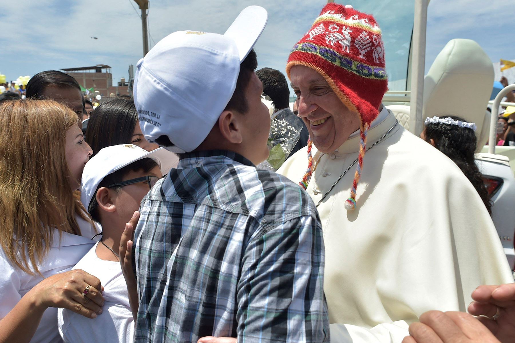 El papa Francisco, con un chullo,  saluda a un niño en la Plaza de Armas del barrio de Buenos Aires, al sureste de la ciudad peruana de Trujillo, el 20 de enero de 2018. El Papa Francisco se dirigió al barrio de Buenos Aires, afectado por el fenómeno meteorológico "El Niño". Foto: AFP / Osservatore Romano