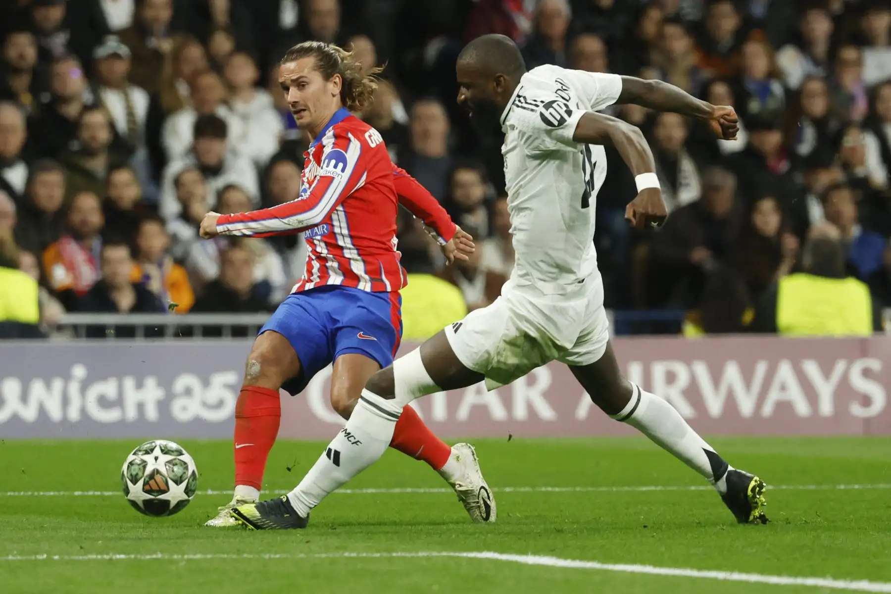 El delantero francés del Atlético de Madrid  Antoine Griezmann realiza un disparo a gol a pesar de ser derribado por el defensa alemán del Real Madrid Antonio Ruediger durante el partido de ida de los octavos de final de la UEFA Champions League entre el Real Madrid CF y el Club Atlético de Madrid. Foto: ANDINA/AFP