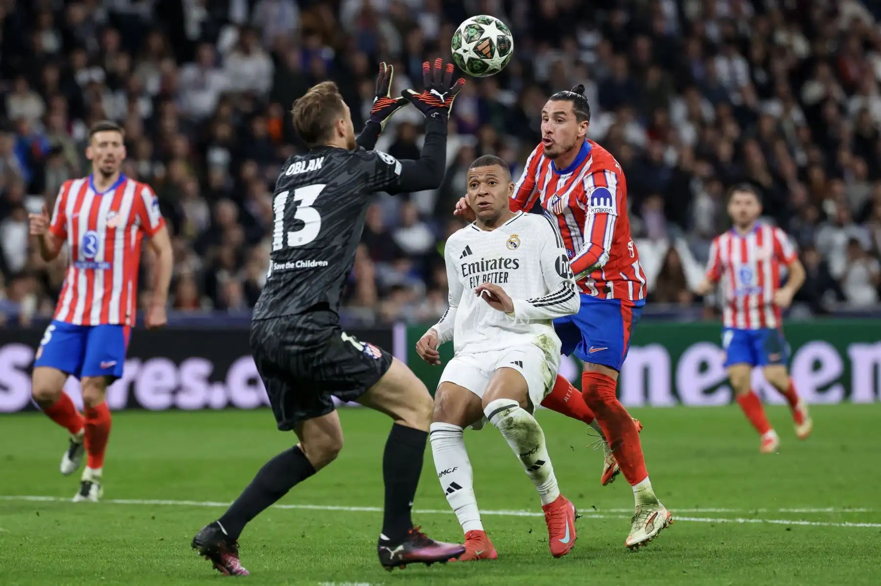 El delantero francés del Real Madrid, Kylian Mbappé, es desafiado por el defensa uruguayo del Atlético de Madrid, José Giménez, y el portero esloveno del Atlético de Madrid, Jan Oblak, durante el partido de ida de los octavos de final de la UEFA Champions League entre el Real Madrid CF y el Club Atlético de Madrid.Foto: ANDINA/AFP