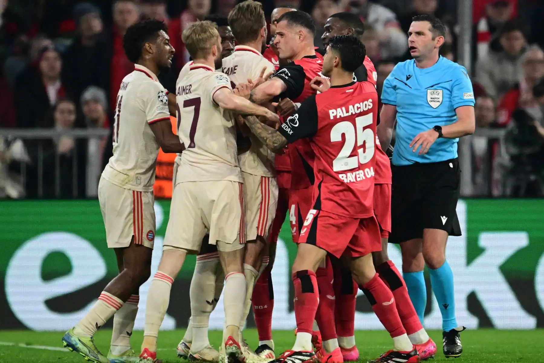 El árbitro inglés Michael Oliver  observa cómo jugadores, incluido el delantero inglés del Bayern Munich Harry Kane y el mediocampista suizo  del Bayer Leverkusen Granit Xhaka, se involucran en una pelea durante el partido de ida de los octavos de final de la UEFA Champions League, FC Bayern Munich vs Bayer 04 Leverkusen.
Foto: AFP