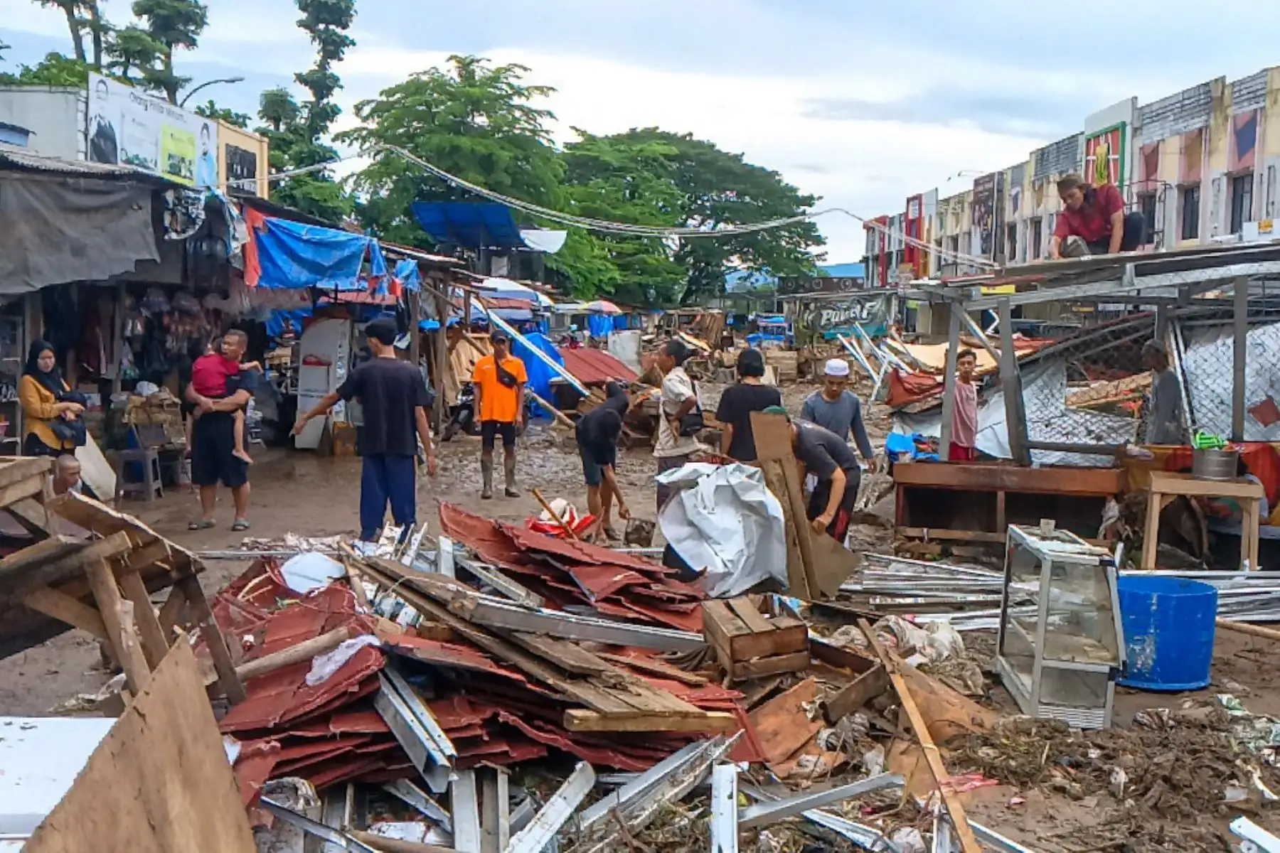 Los residentes recogen objetos que pueden rescatar en Sukabumi, Java Occidental, el 7 de marzo de 2025, después de que una inundación repentina azotara la zona. Foto: AFP