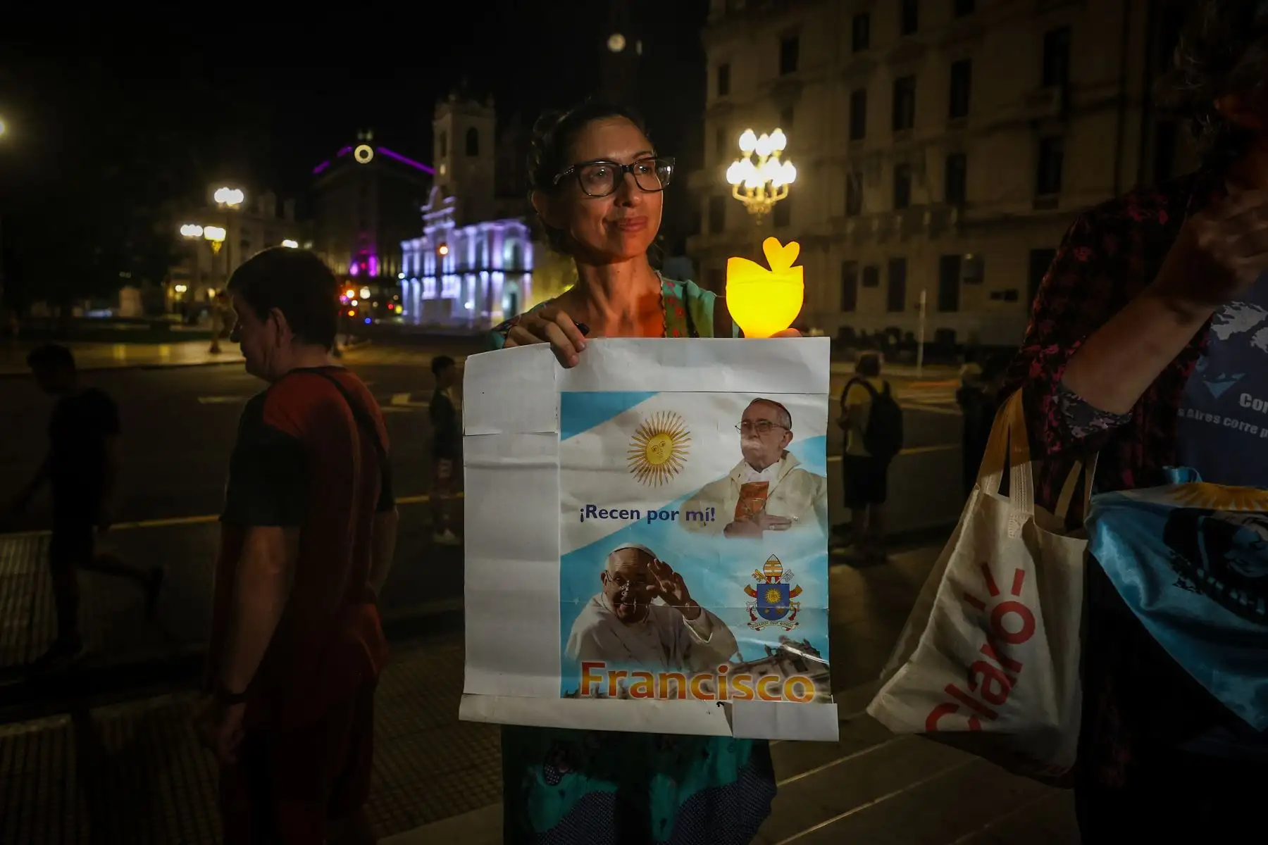 Una mujer sostiene un cartel del papa Francisco durante una marcha para pedir por su salud frente a la Catedral de Buenos Aires este viernes. Foto: EFE/AFP
