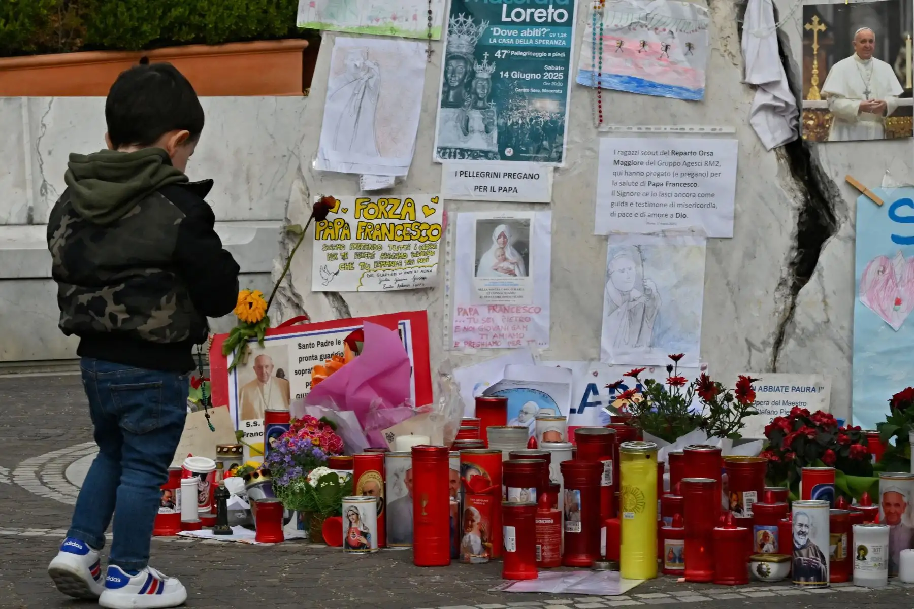 Un niño se encuentra junto a la estatua de Juan Pablo II afuera del Hospital Universitario Gemelli, donde el Papa Francisco está hospitalizado con neumonía, en Roma.
Foto: AFP