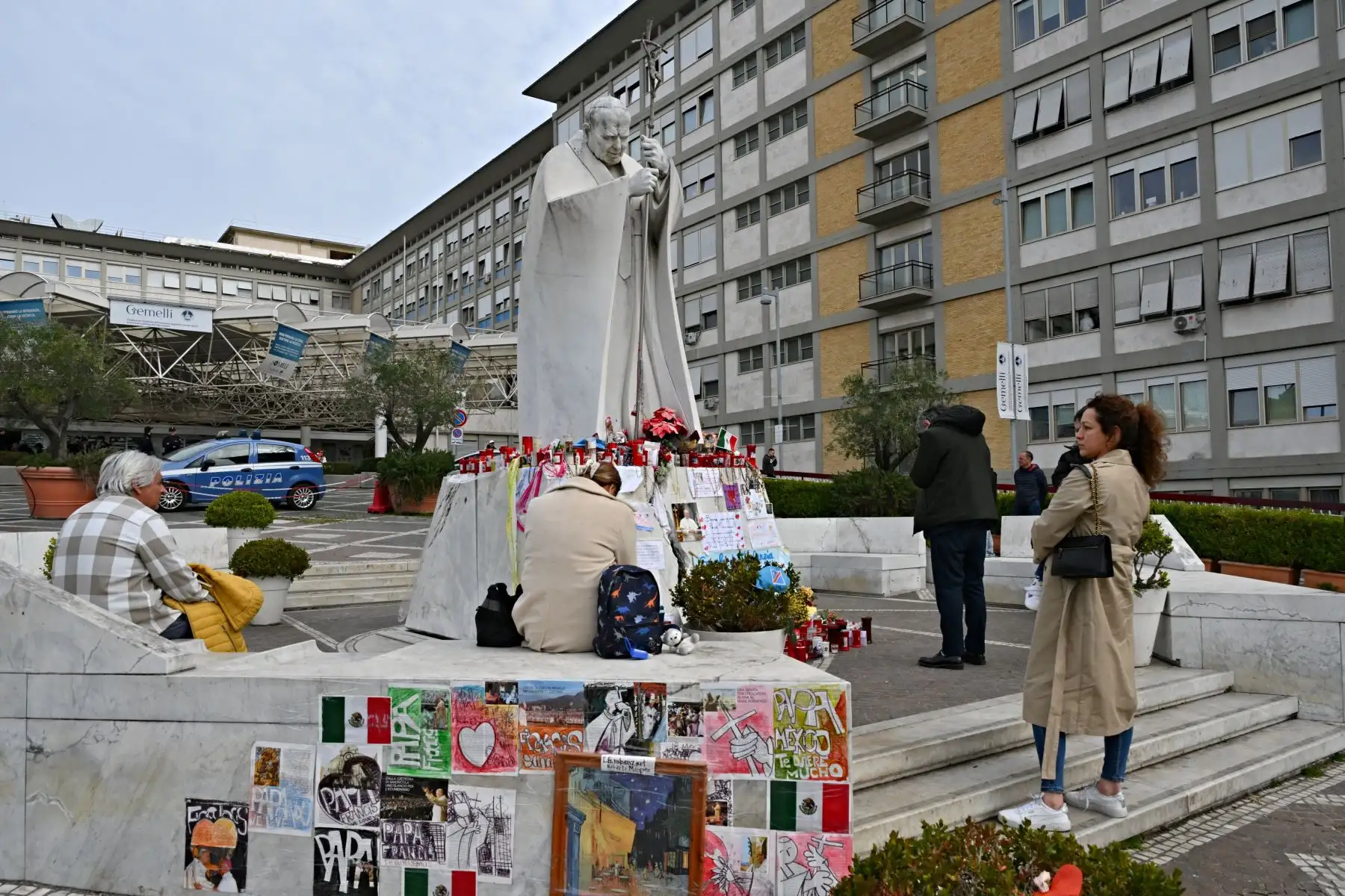La gente se encuentra ante la estatua de Juan Pablo II afuera del Hospital Universitario Gemelli, donde el Papa Francisco está hospitalizado con neumonía, en Roma.
Foto: AFP