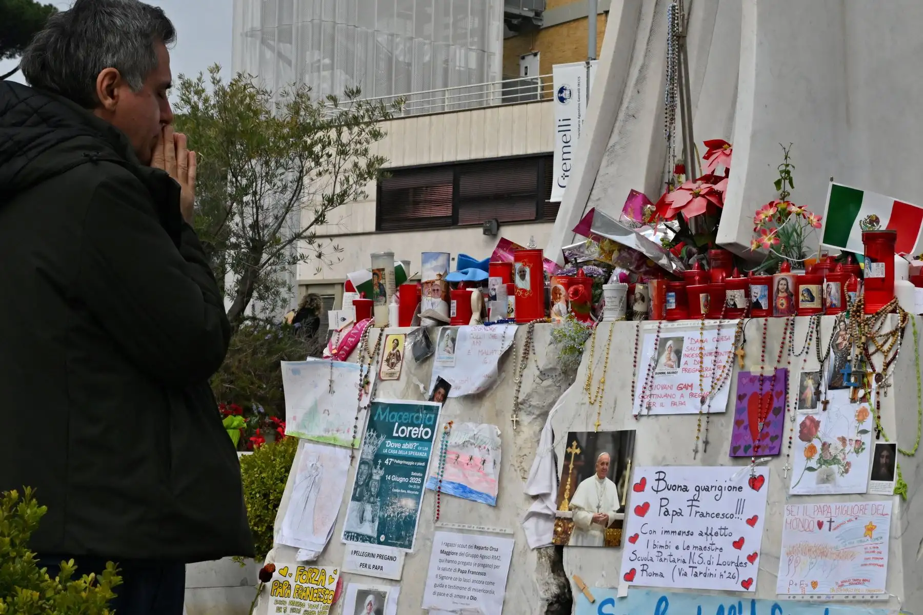 Un hombre reza ante la estatua de Juan Pablo II afuera del Hospital Universitario Gemelli, donde el Papa Francisco está hospitalizado con neumonía, en Roma.
Foto: AFP