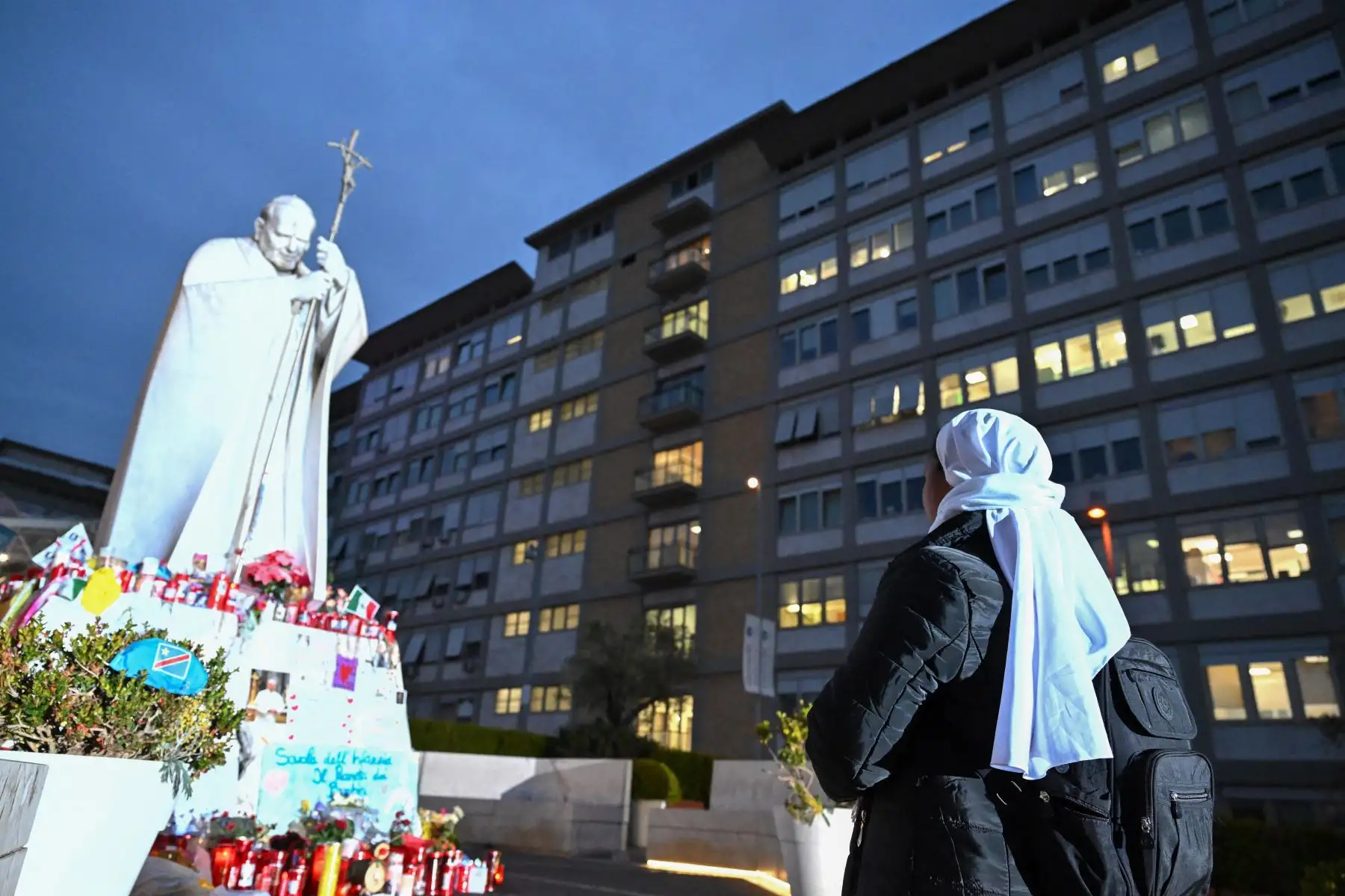 Las monjas rezan a los pies de una estatua de Juan Pablo II en el Hospital Gemelli, donde está internado el papa Francisco, en Roma, El papa Francisco pasó una noche tranquila en el hospital, dijo el Vaticano, mientras el líder de la Iglesia católica de 88 años lucha contra una neumonía. 
Foto: ANDINA/AFP