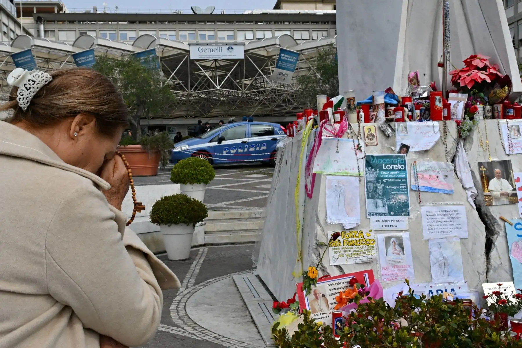 Una mujer reza ante la estatua de Juan Pablo II en el exterior del Hospital Universitario Gemelli, donde el papa Francisco está internado por neumonía, en Roma. El papa Francisco pasó una noche tranquila en el hospital, dijo el Vaticano, mientras el líder de la Iglesia católica de 88 años lucha contra la neumonía. Foto: ANDINA/AFP