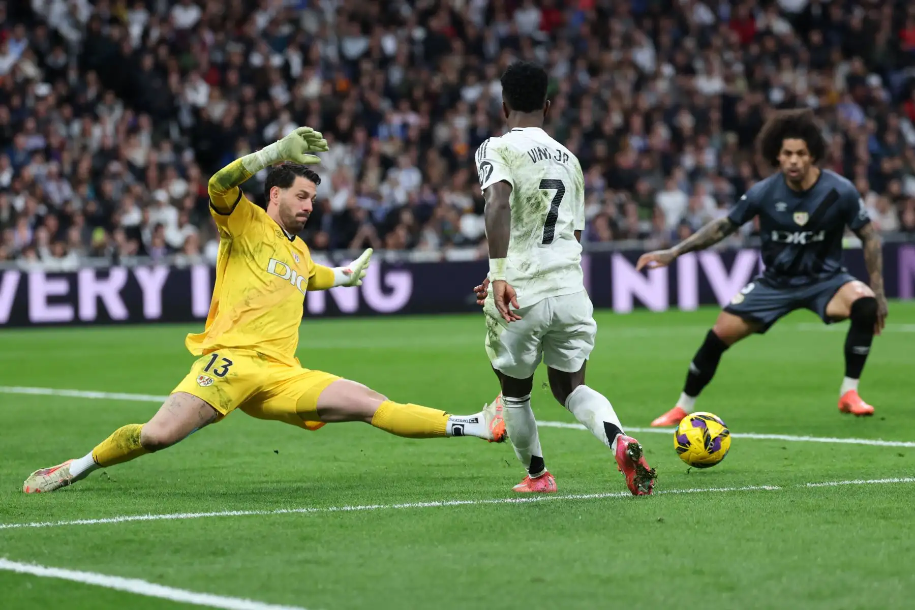 El portero argentino del Rayo Vallecano, Augusto Batalla, se estira para despejar el balón contra el delantero brasileño del Real Madrid, Vinicius Junior, durante el partido de fútbol de la liga española entre el Real Madrid CF y el Rayo Vallecano de Madrid en el estadio Santiago Bernabéu en Madrid. Foto: ANDINA/AFP