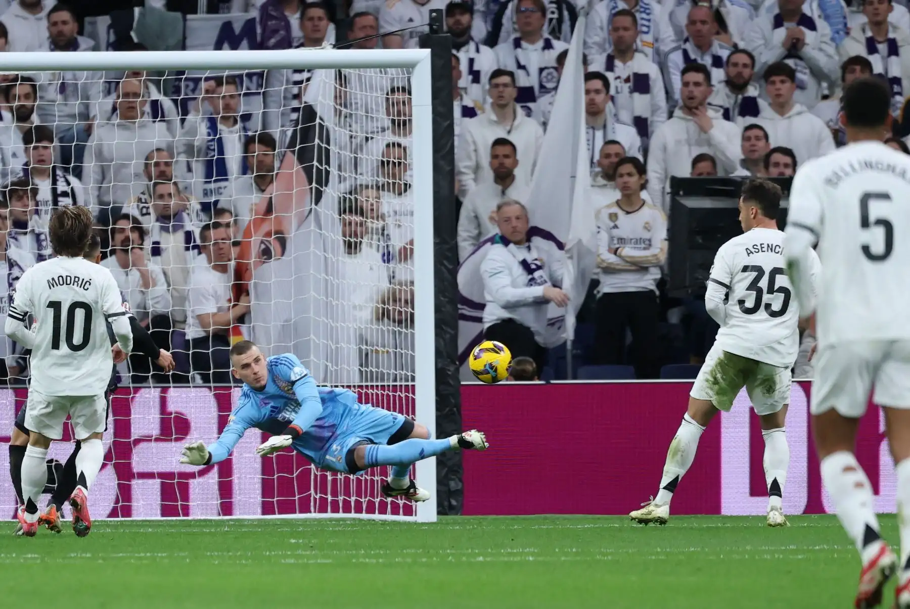 El portero ucraniano del Real Madrid, Andriy Lunin, se lanza por el balón después de que el mediocampista español del Rayo Vallecano, Gerard Gumbau Garriga, realizó un remate al arco durante el partido de fútbol de la liga española entre el Real Madrid CF y el Rayo Vallecano de Madrid. Foto: ANDINA/AFP