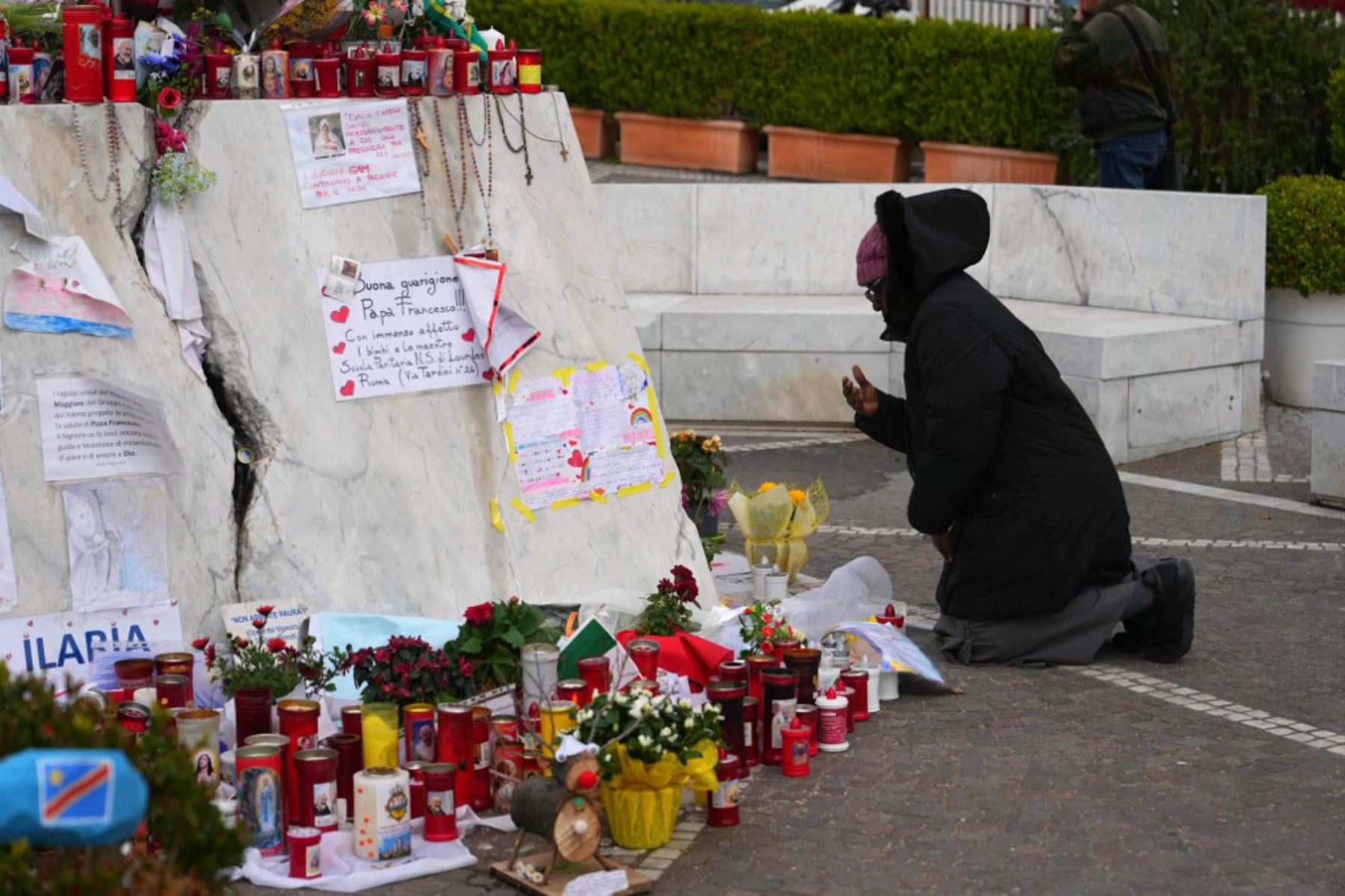 Una persona reza ante la estatua de Juan Pablo II en el exterior del Hospital Universitario Gemelli, donde el Papa Francisco está hospitalizado por neumonía, en Roma. Foto: AFP