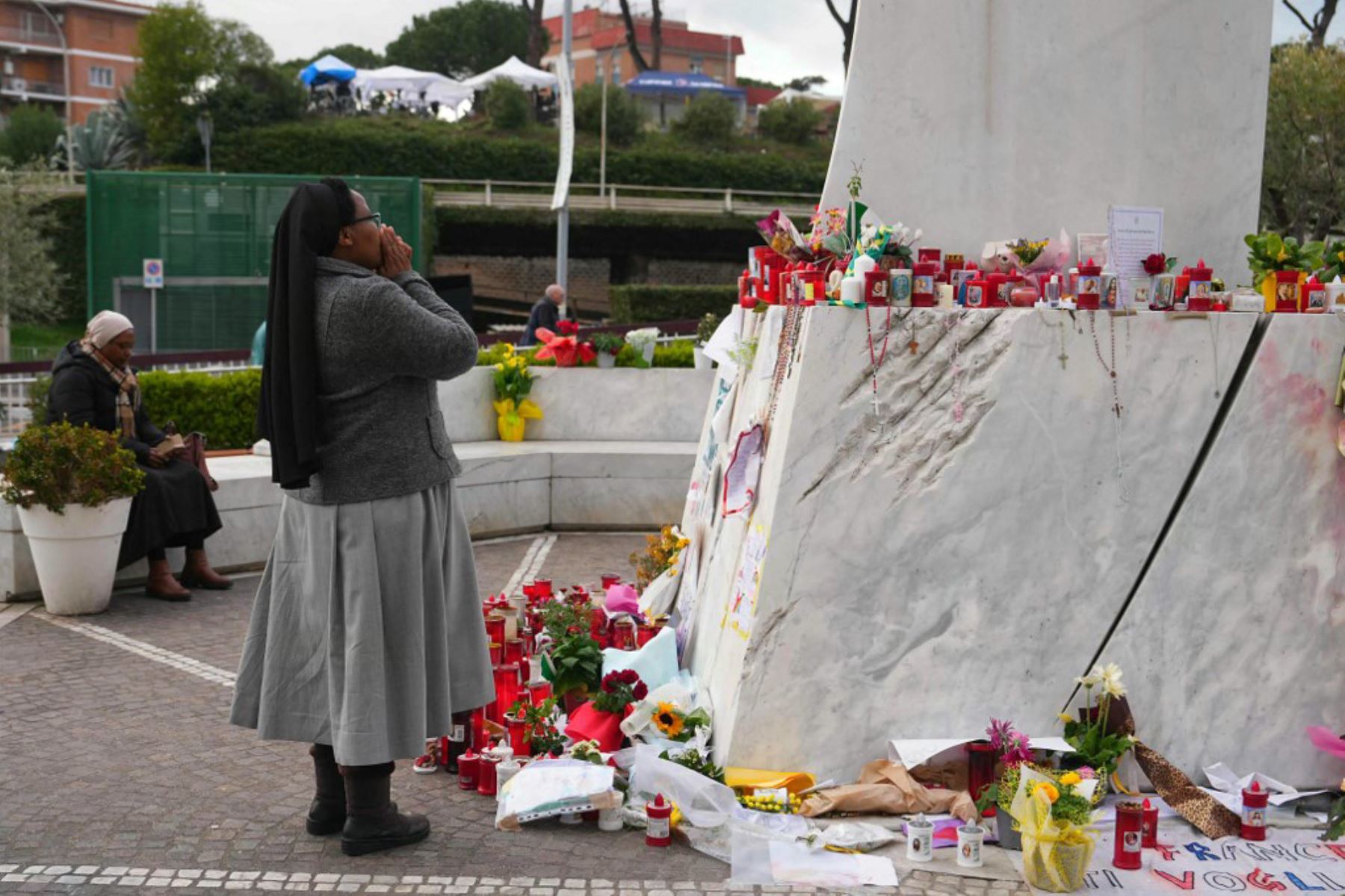 Una monja reza ante la estatua de Juan Pablo II en el exterior del Hospital Universitario Gemelli, donde el Papa Francisco está hospitalizado por neumonía, en Roma