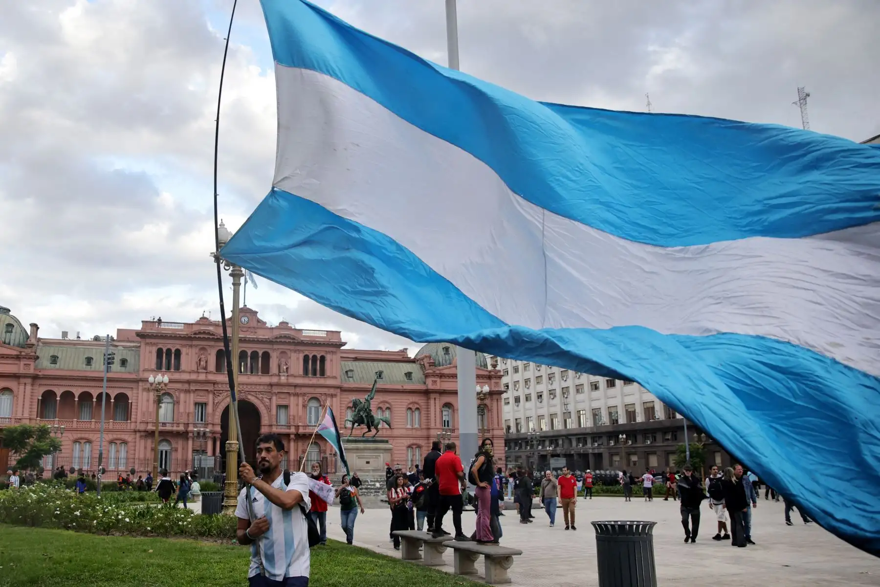 Un manifestante ondea una bandera argentina gigante frente al palacio presidencial de la Casa Rosada durante una protesta de jubilados apoyados por aficionados al fútbol contra el gobierno del presidente Javier Milei en Buenos Aires. AFP