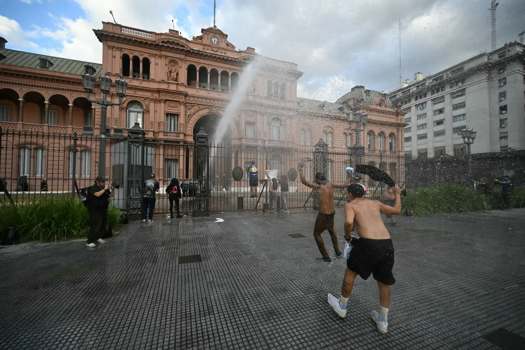 Los manifestantes escalan una valla frente al palacio presidencial de la Casa Rosada durante una protesta de jubilados apoyados por aficionados al fútbol contra el gobierno del presidente Javier Milei en Buenos Aires. AFP
