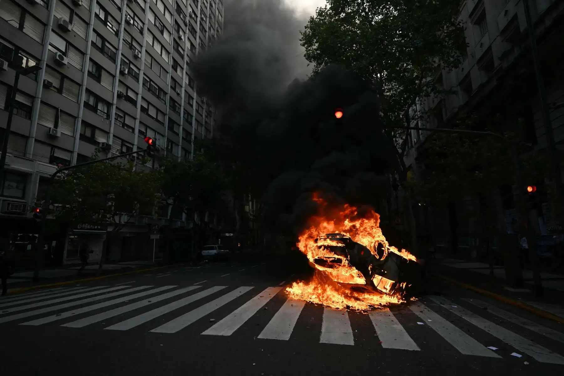 Un auto en llamas durante una protesta de jubilados apoyados por fanáticos del fútbol contra el gobierno del presidente Javier Milei en Buenos Aires. AFP