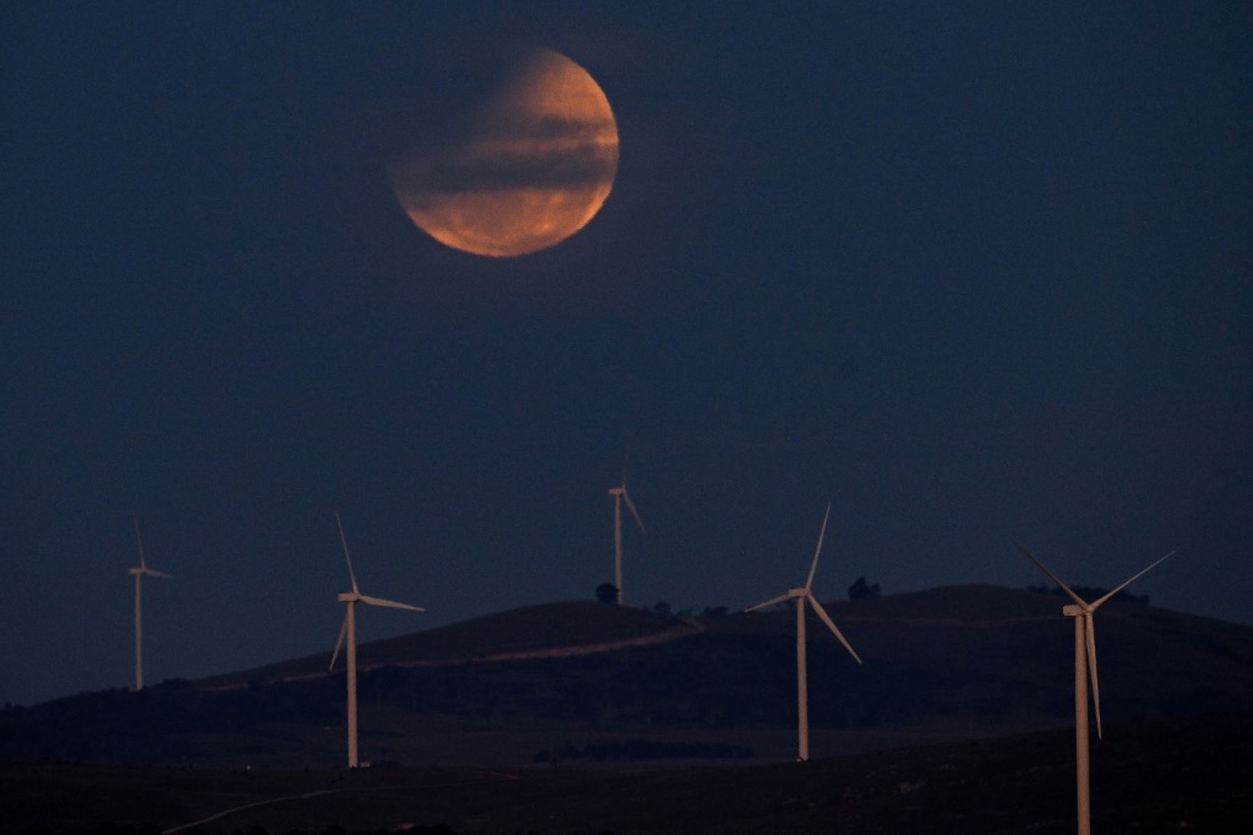 Una luna llena, también conocida como "Luna de Sangre", se observa durante un eclipse parcial en el cielo sobre el lago George, cerca de Canberra, la capital australiana, el 14 de marzo de 2025. Los astrónomos de todo el mundo se maravillaron con una espectacular "Luna de Sangre" roja durante un inusual eclipse lunar total en la madrugada del 14 de marzo. Foto: AFP