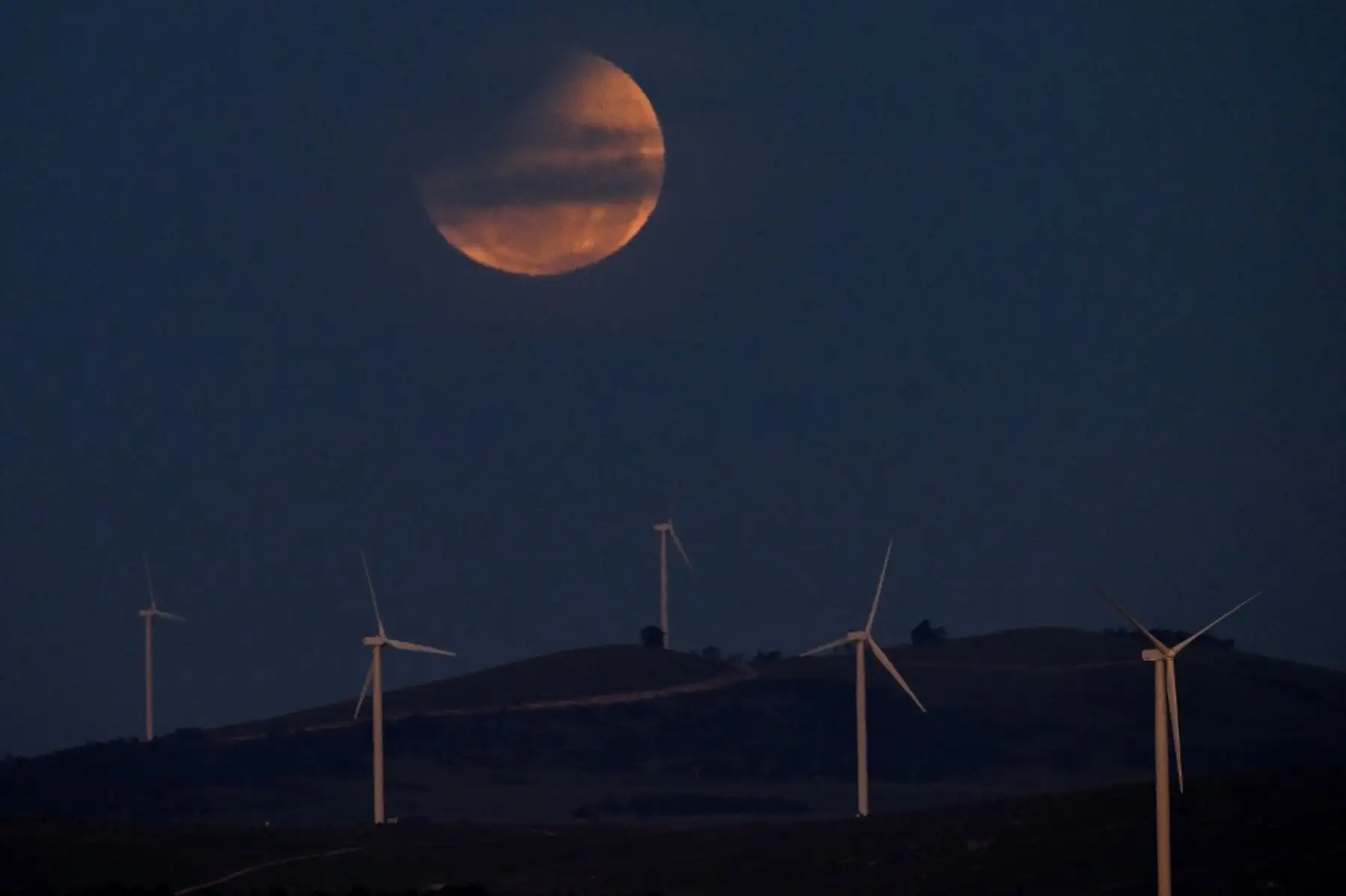 Una luna llena, también conocida como "Luna de Sangre", se observa durante un eclipse parcial en el cielo sobre el lago George, cerca de Canberra, la capital australiana, el 14 de marzo de 2025. Los astrónomos de todo el mundo se maravillaron con una espectacular "Luna de Sangre" roja durante un inusual eclipse lunar total en la madrugada del 14 de marzo. Foto: AFP