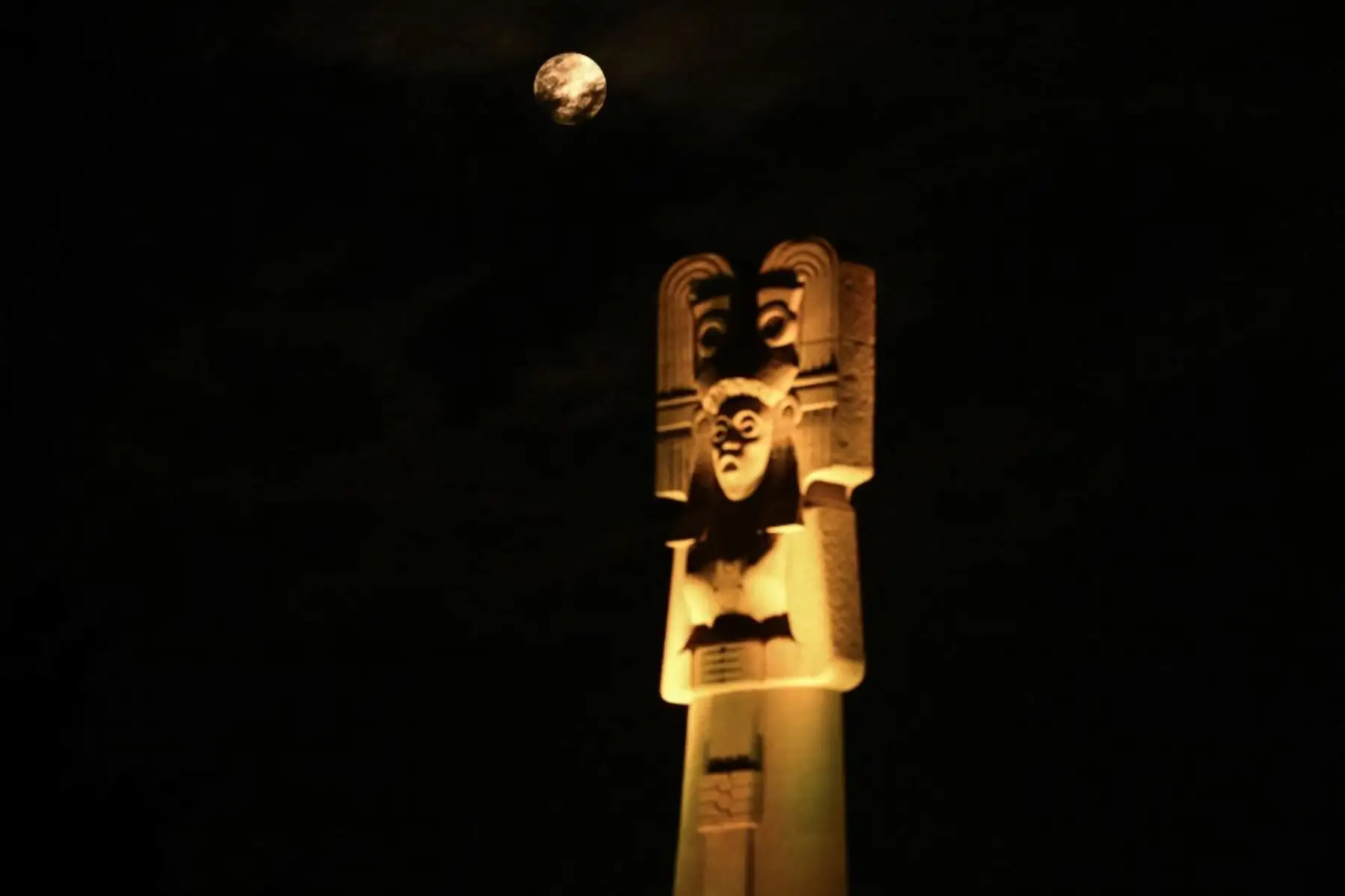 Una luna llena, también conocida como "luna de sangre", se observa junto al monumento "Joven de Amajac", erigido en la Avenida Reforma para reivindicar la lucha de las mujeres indígenas en la Ciudad de México el 13 de marzo de 2025, antes del eclipse lunar. Foto: AFP