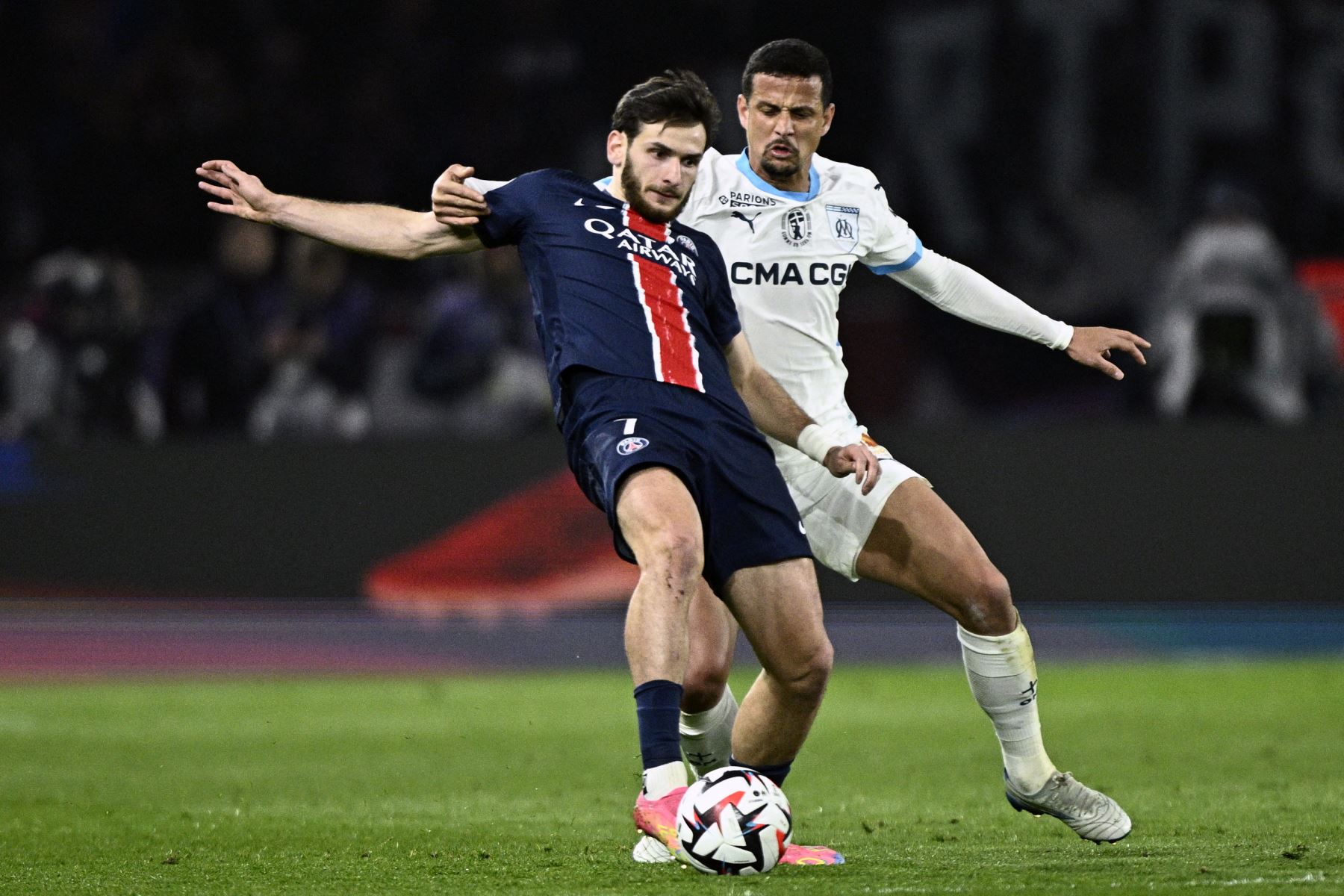 El delantero georgiano del Paris Saint-Germain, Khvicha Kvaratskhelia,  disputa el balón con el defensa italiano del Marsella, Luiz Felipe, durante el partido de la primera división francesa entre el Paris Saint-Germain y el Olympique de Marsella , en el estadio Parc des Princes de París.
Foto: AFP