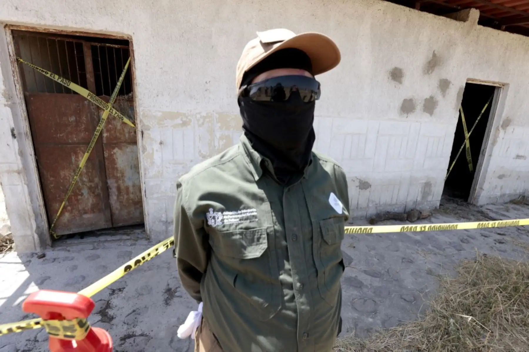 Un miembro de la Comisión Nacional de Búsqueda (CNB) resguarda un área acordonada del "Rancho Izaguirre" durante una gira de prensa en Tehuchitlán, estado de Jalisco, México, el 20 de marzo de 2025. Se realizan investigaciones sobre lo que sucedió en un supuesto campo de entrenamiento de un cártel de la droga donde se encontraron huesos, zapatos y ropa carbonizados a principios de marzo. Foto: AFP