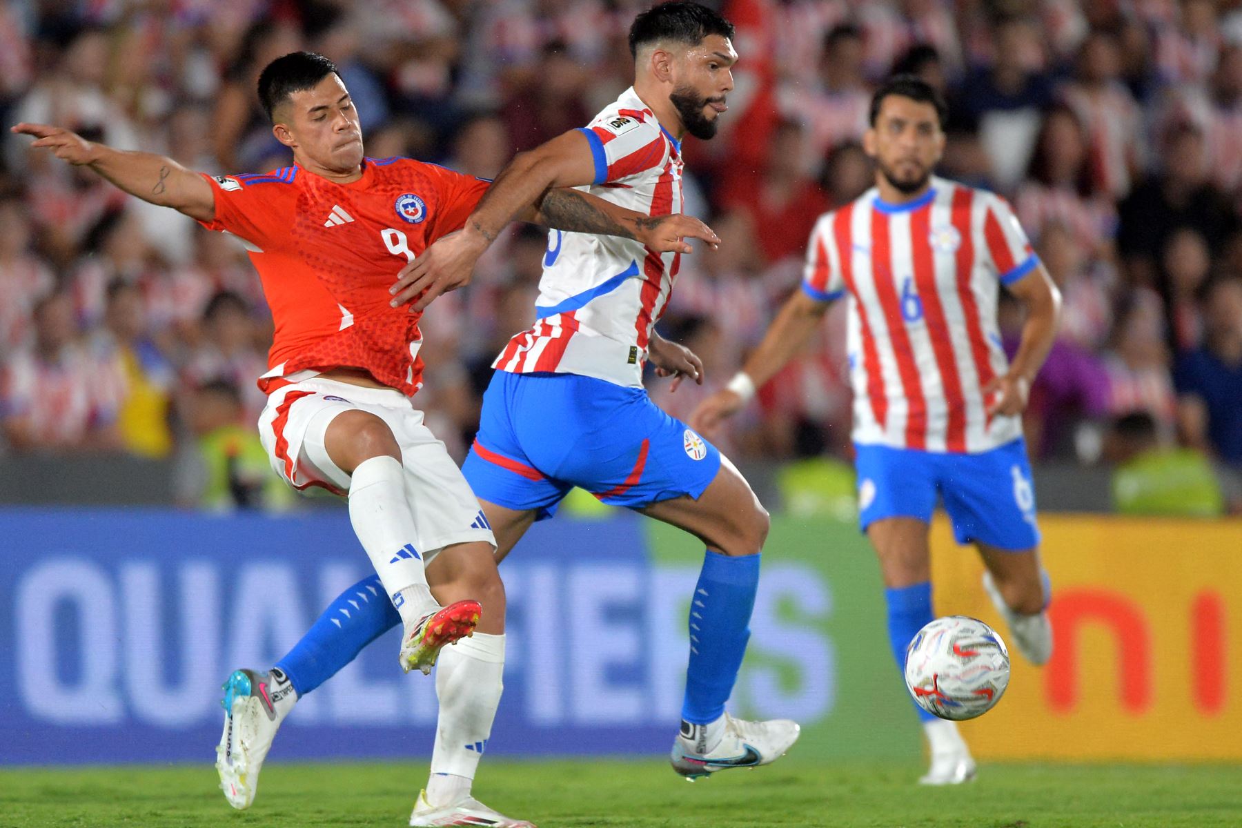 El delantero de Chile, Alexander Aravena, y el defensor de Paraguay, Omar Alderete, luchan por el balón durante el partido de clasificación sudamericana para la Copa Mundial de la FIFA 2026 entre Paraguay y Chile en el estadio Defensores del Chaco en Asunción el 20 de marzo de 2025. Foto: AFP
