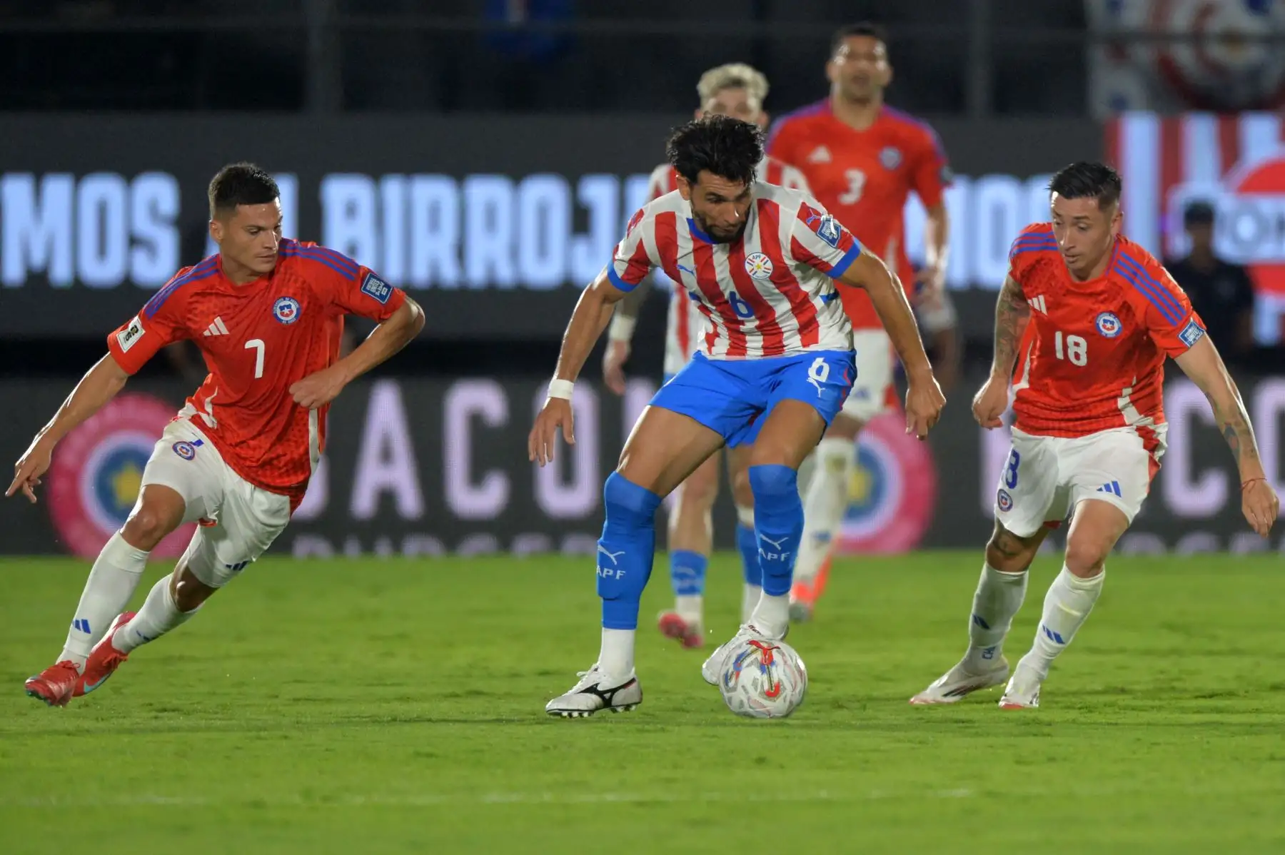 El defensor de Paraguay Junior Alonso lucha por el balón con el delantero de Chile Lucas Cepeda y el mediocampista Rodrigo Echeverría durante el partido de fútbol de las eliminatorias sudamericanas de la Copa Mundial de la FIFA 2026 entre Paraguay y Chile en el estadio Defensores del Chaco en Asunción el 20 de marzo de 2025. Foto: AFP