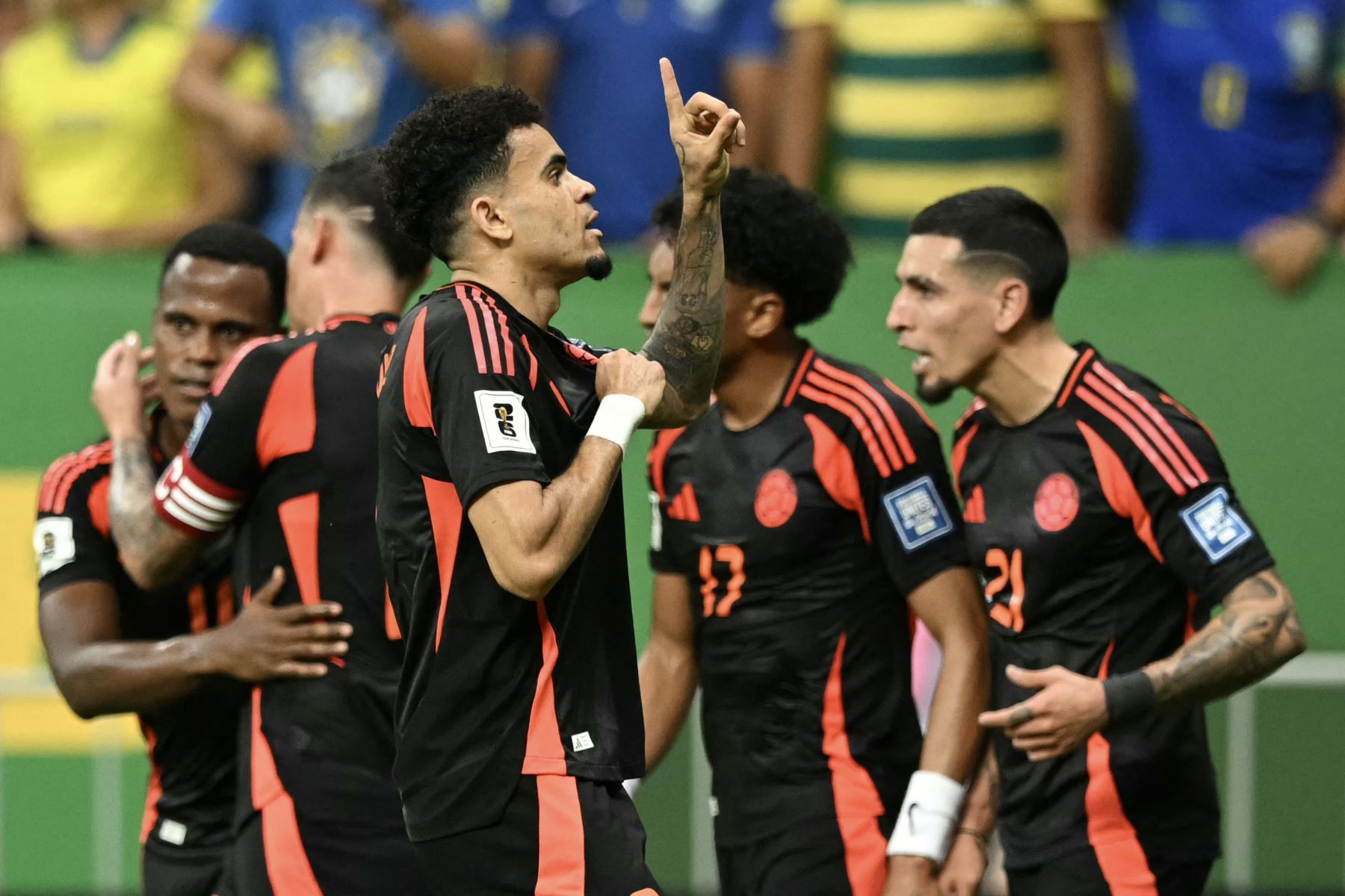 El delantero colombiano Luis Díaz celebra con sus compañeros de equipo después de anotar durante el partido de fútbol de las eliminatorias sudamericanas de la Copa Mundial de la FIFA 2026 entre Brasil y Colombia, en el estadio Mane Garrincha en Brasilia, el 20 de marzo de 2025. Foto: AFP