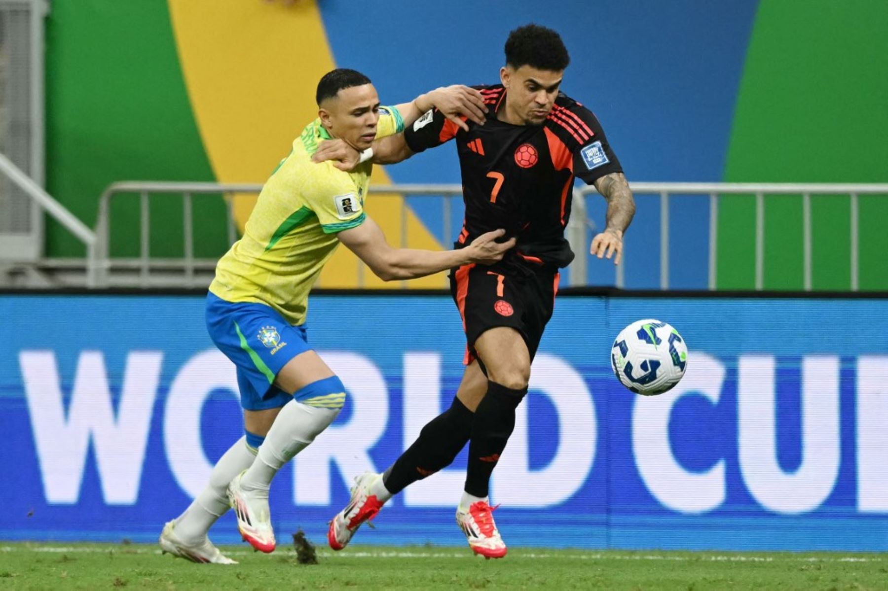 El defensor brasileño Vanderson y el delantero colombiano Luis Díaz luchan por el balón durante el partido de fútbol de las eliminatorias sudamericanas de la Copa Mundial de la FIFA 2026 entre Brasil y Colombia, en el estadio Mane Garrincha en Brasilia, el 20 de marzo de 2025. Foto: AFP