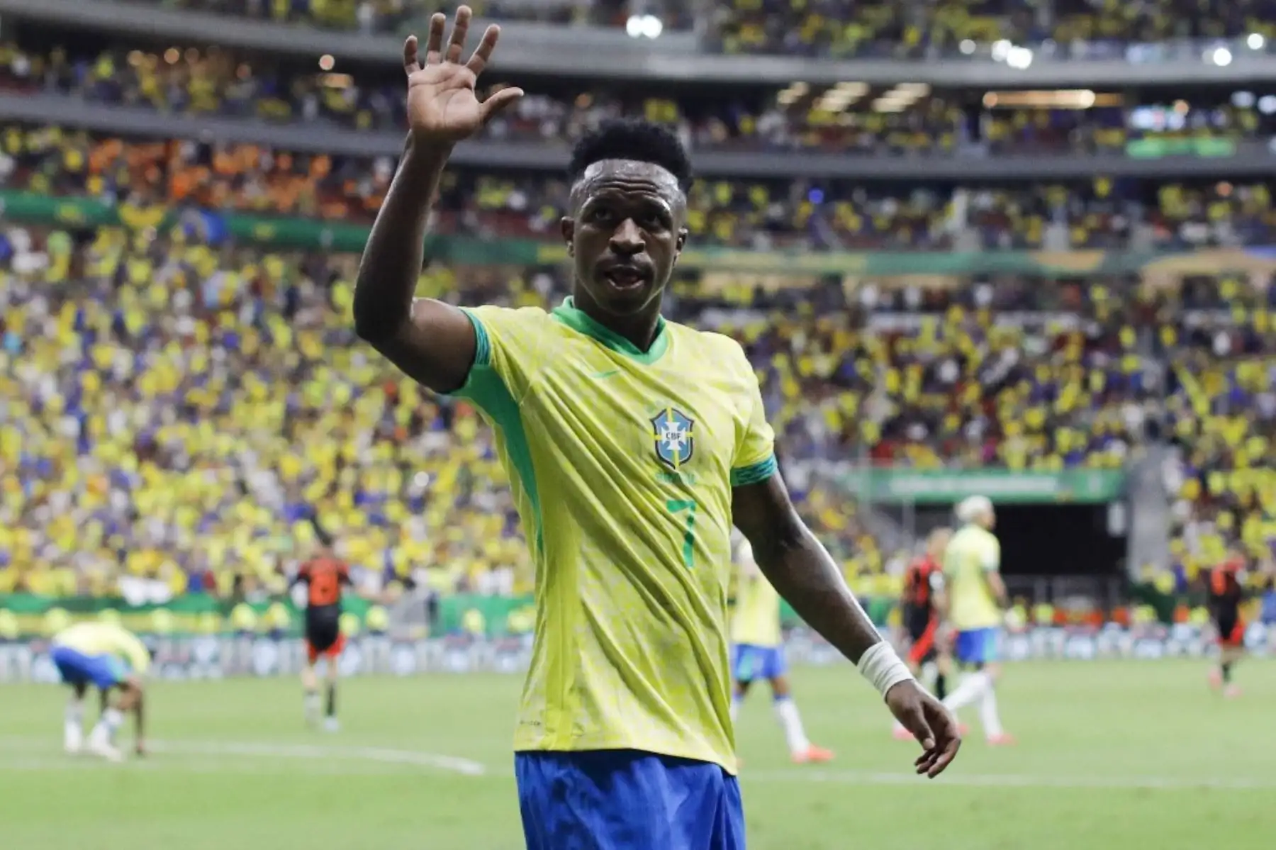 El delantero brasileño Vinicius Jr saluda a los hinchas de su selección durante el partido de fútbol de las eliminatorias sudamericanas de la Copa Mundial de la FIFA 2026 entre Brasil y Colombia, en el estadio Mane Garrincha en Brasilia, el 20 de marzo de 2025. Foto: AFP
