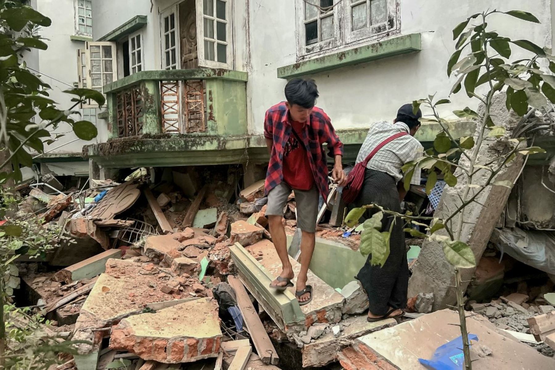 Residentes caminan sobre escombros junto a un edificio dañado en Naipyidó el 28 de marzo de 2025, tras un terremoto en el centro de Myanmar. Un potente terremoto sacudió Myanmar deformando las carreteras de la capital, Naipyidó, dañando edificios y obligando a la gente a huir a las calles en la vecina Tailandia. Foto: AFP