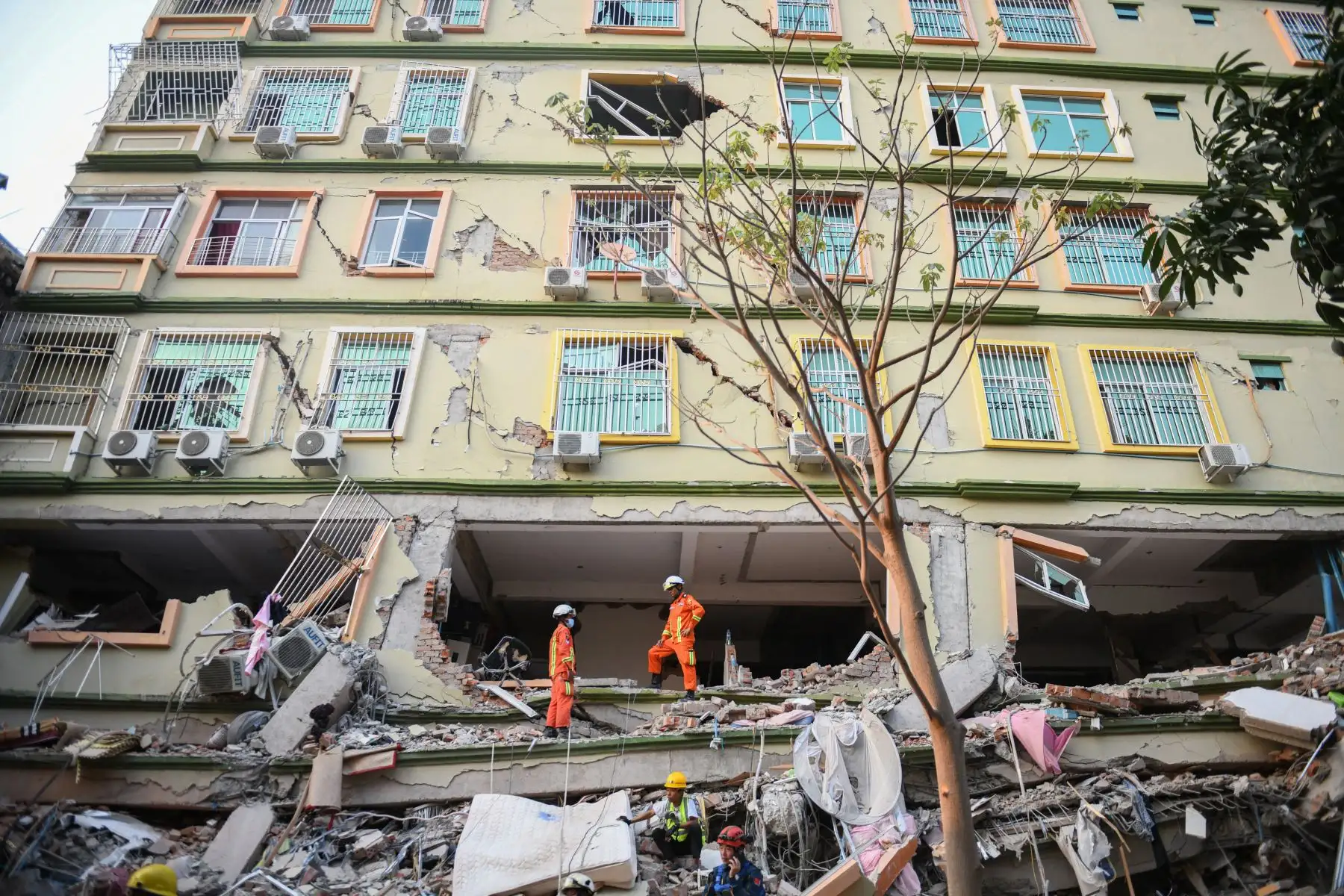 Los equipos de rescate trabajan para evacuar a los residentes atrapados bajo los escombros del edificio derrumbado 