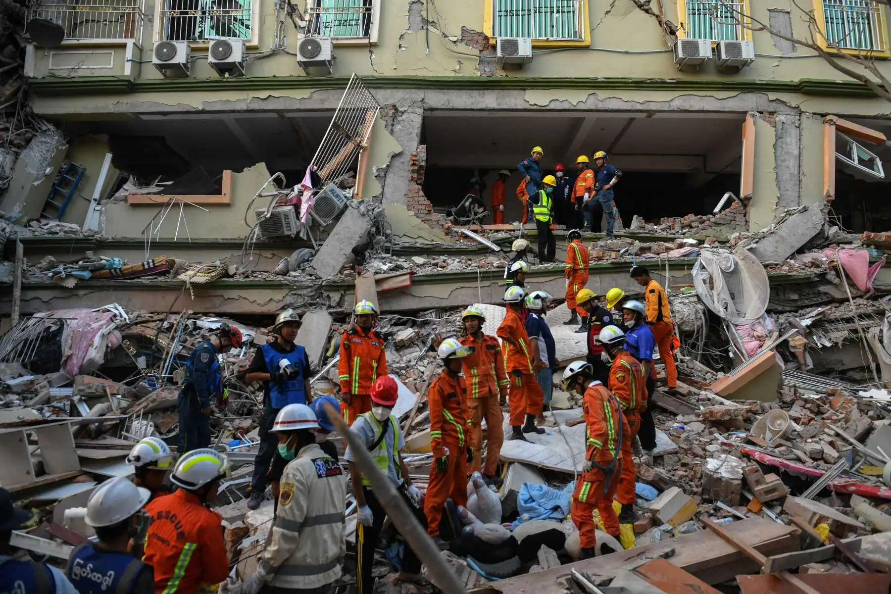 Equipos de rescate trabajan para evacuar a los residentes atrapados bajo los escombros del edificio derrumbado 