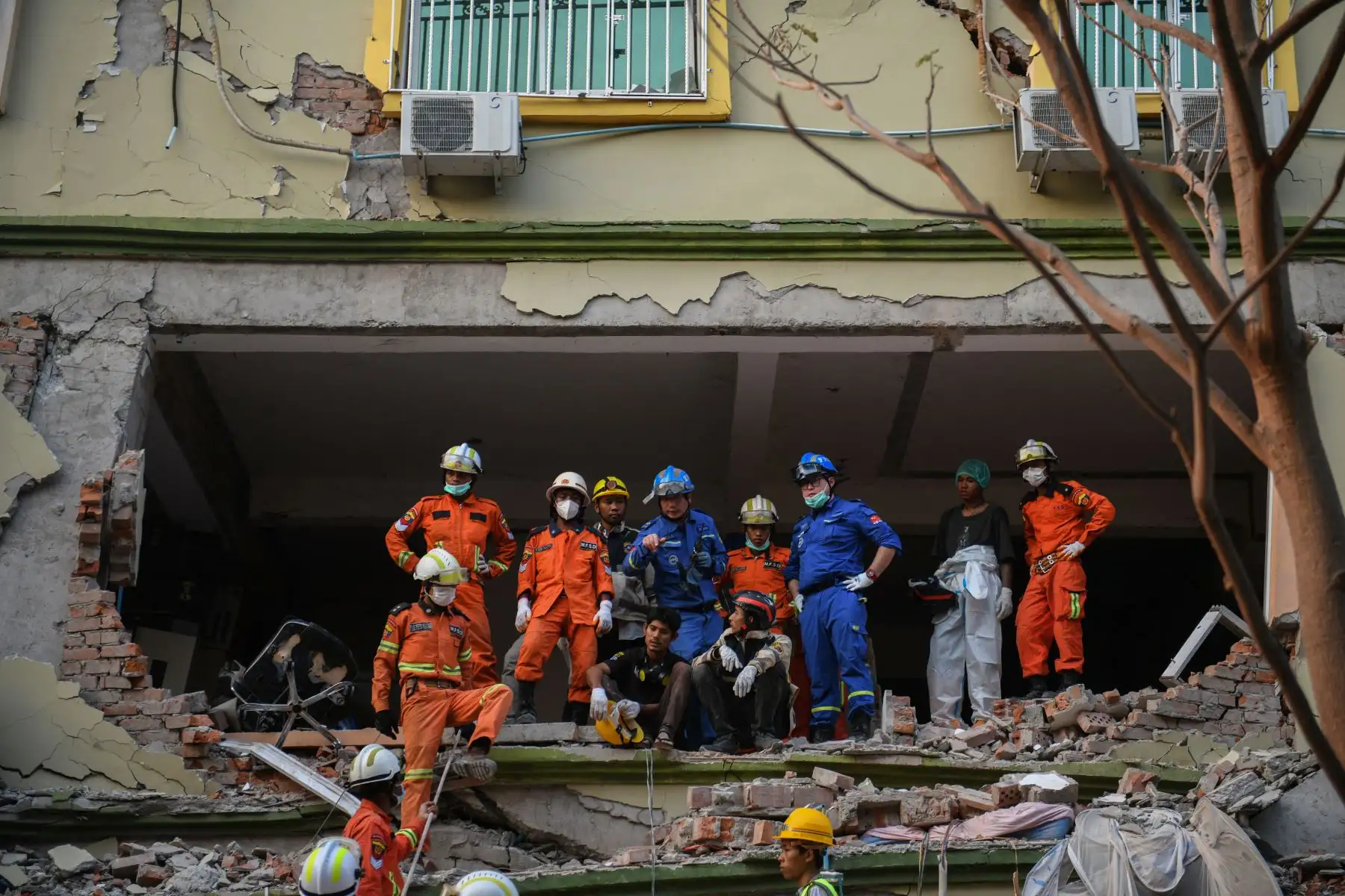 Los equipos de rescate trabajan para evacuar a los residentes atrapados bajo los escombros del edificio derrumbado 