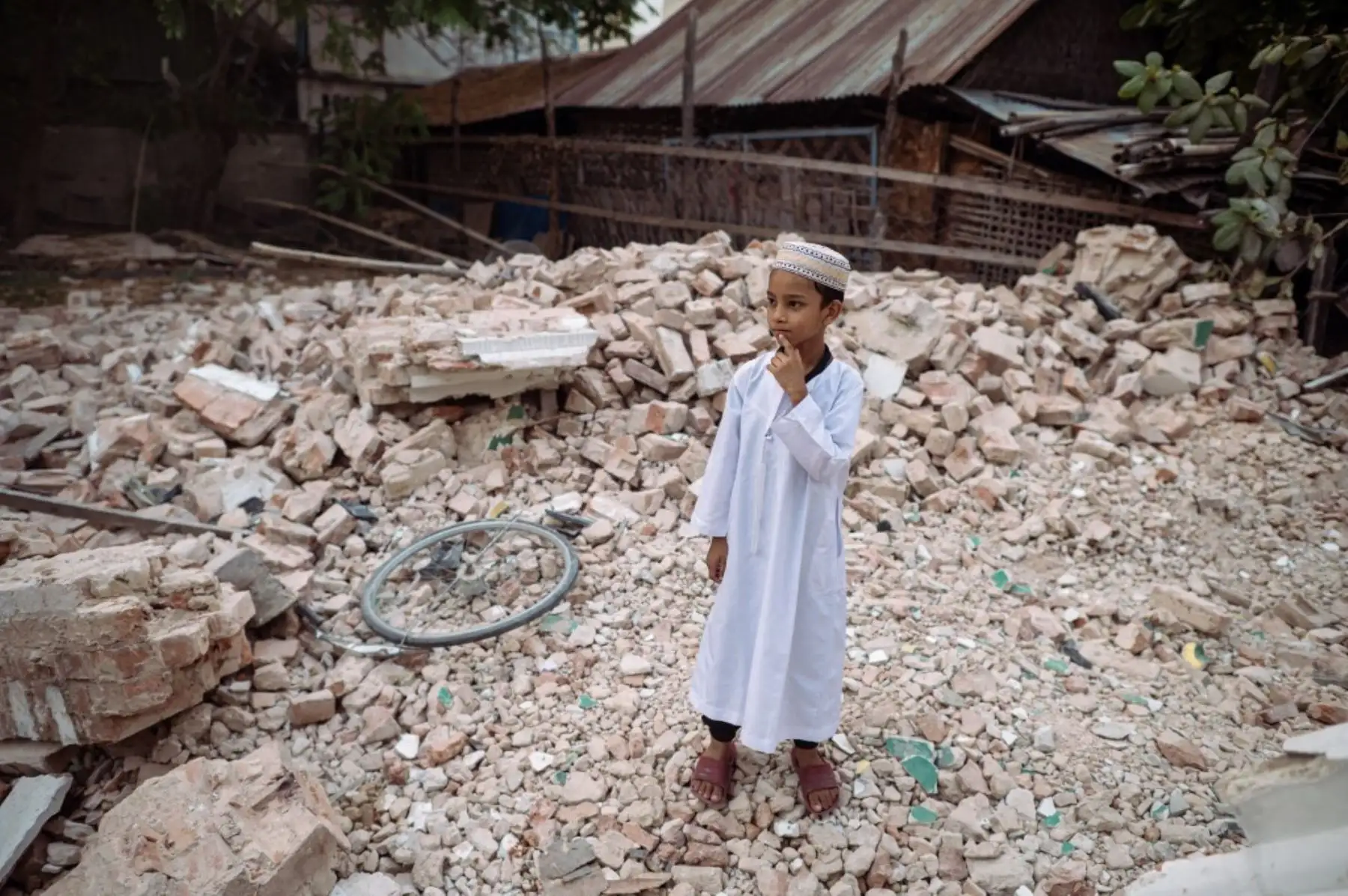 Un niño musulmán permanece de pie sobre los escombros de un edificio derrumbado en Mandalay el 31 de marzo de 2025, tres días después del mortífero terremoto de Myanmar. Foto: AFP