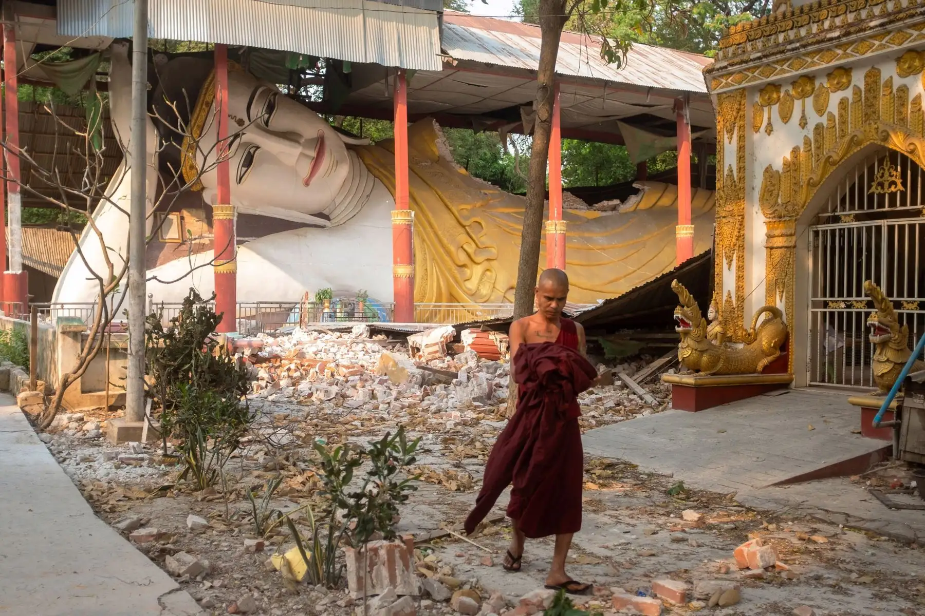 Un monje pasa junto a una escultura de Buda en un templo dañado tras un terremoto en Mandalay, Myanmar. Foto: EFE